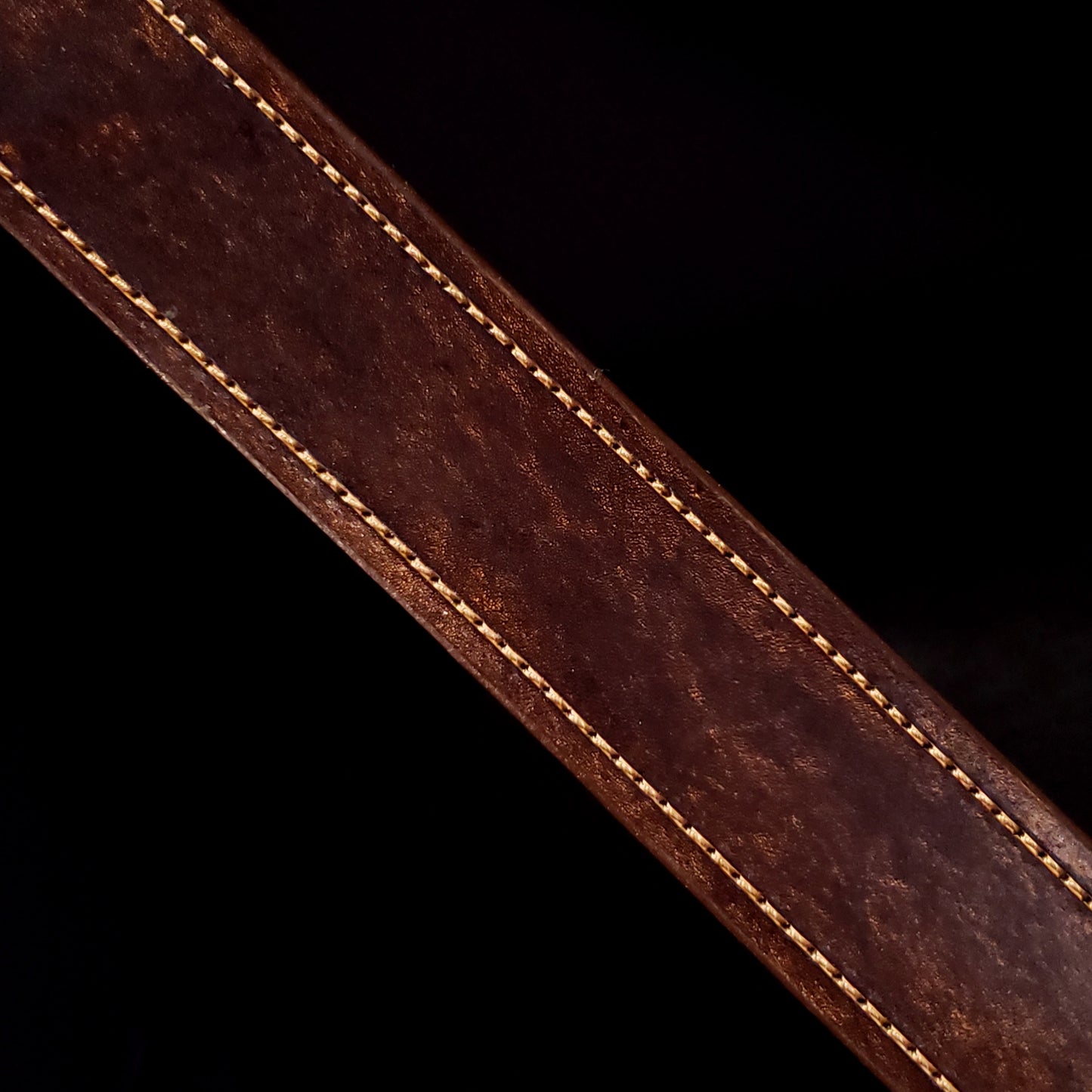 Brown leather belt strap with light brown consistent stitching along either side.