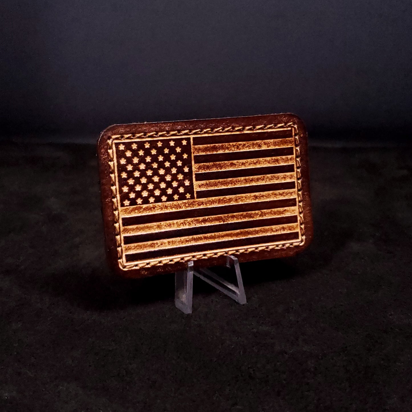 Brown rectangular velcro patch embossed with the American flag, posed on a black background.