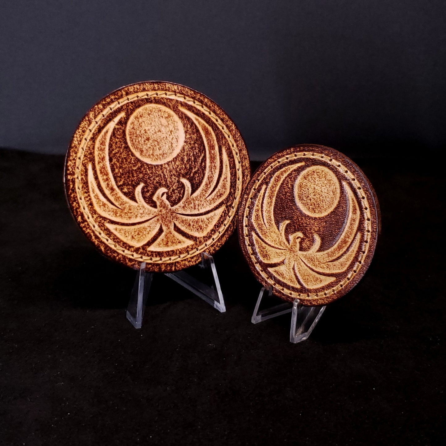 Two brown leather velcro patches embossed with the Skyrim nightingale symbol from the Elder Scrolls franchise, posed on a black background.