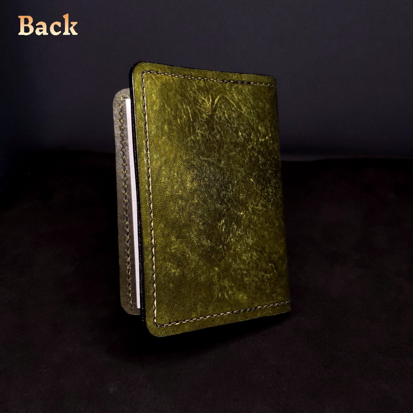 Olie-green leather mini-composition cover, closed and viewed from the back