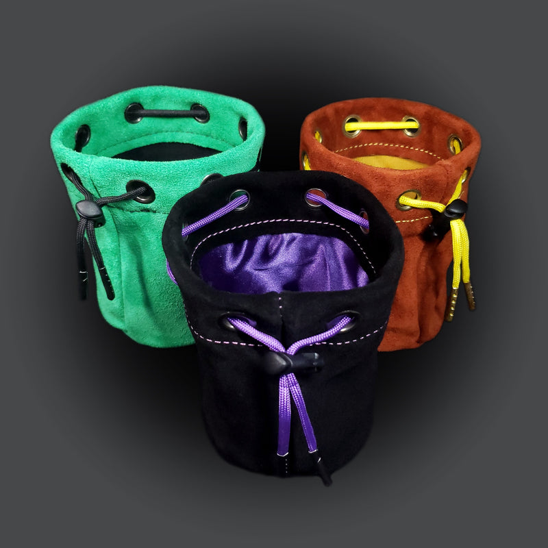 Three suede leather drawstring pouches of different colors.
