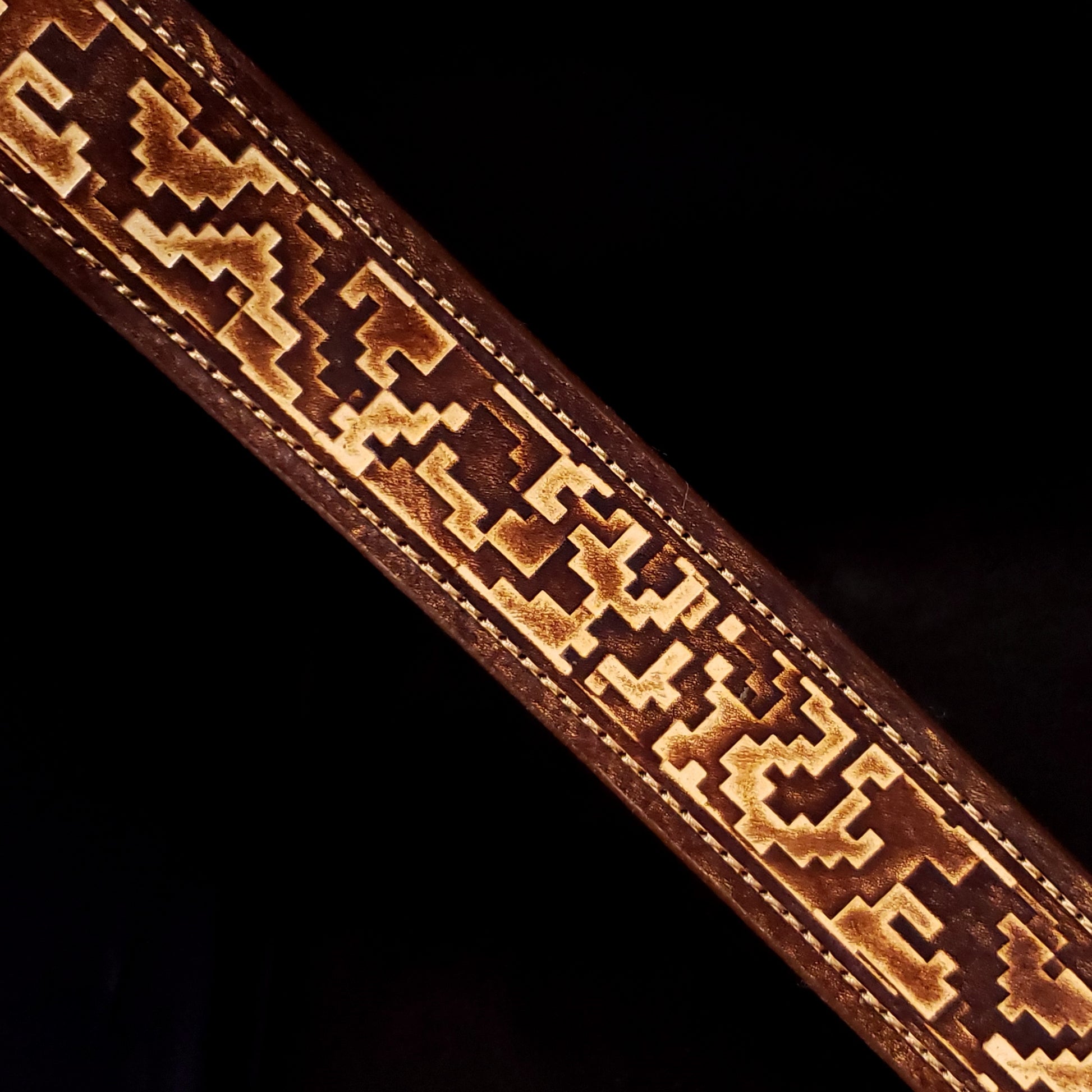 Brown leather belt strap with consistent stitching and a digital camouflage pattern.