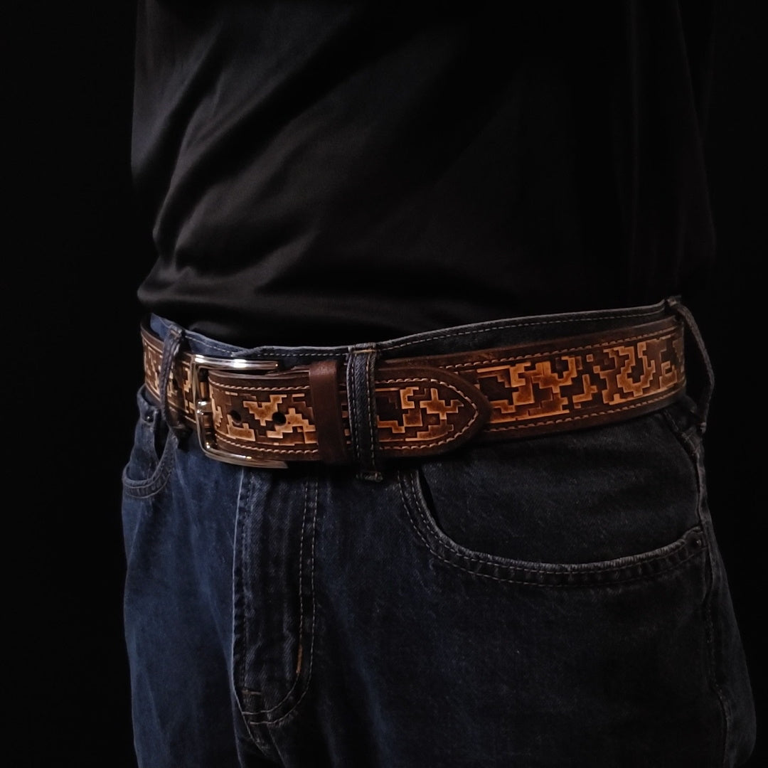 Brown leather belt with a silver buckle and decorated with a digital camouflage pattern, being worn by a man with jeans.