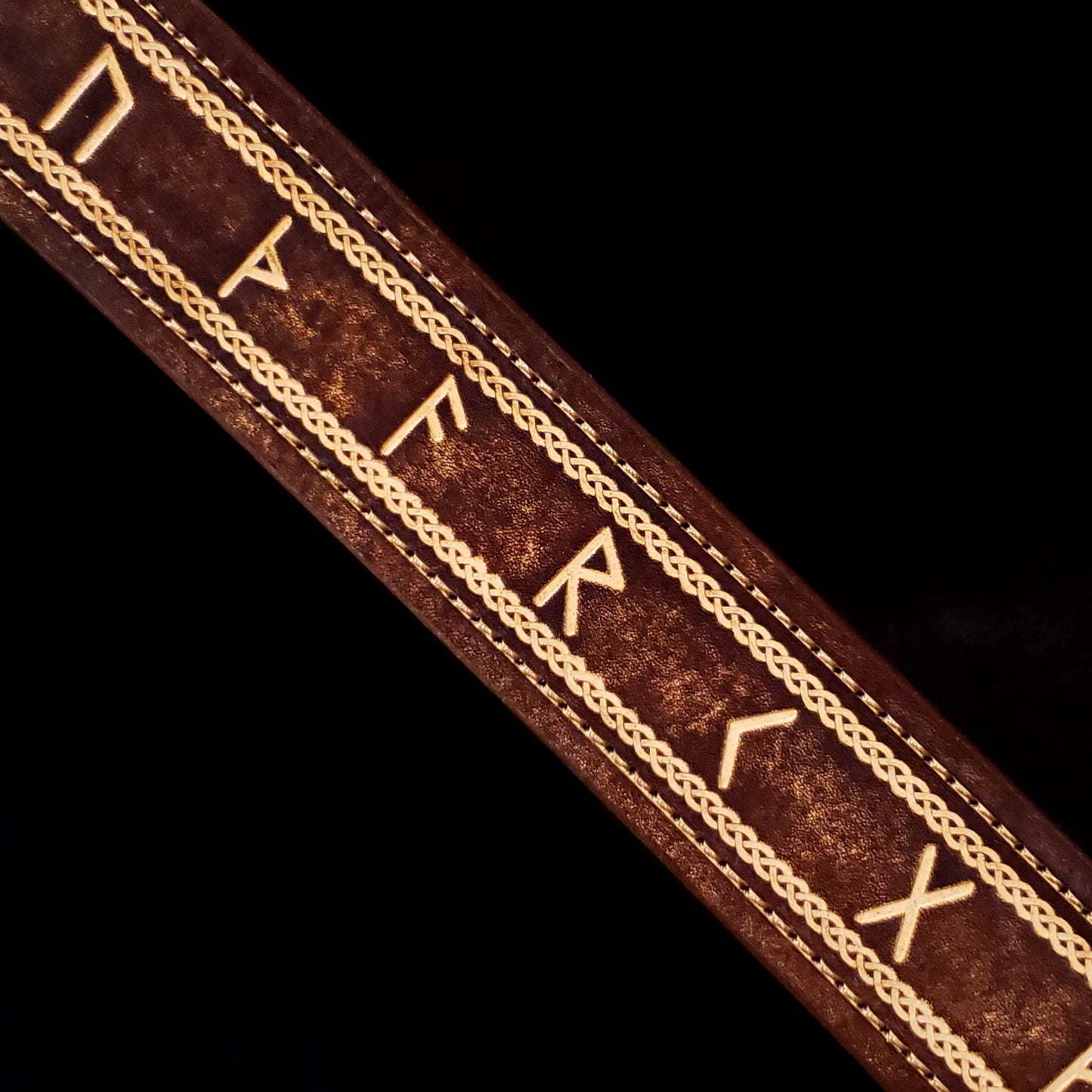 Brown leather belt strap with consistent stitching and a decorative Celtic knot pattern with Norse runes.