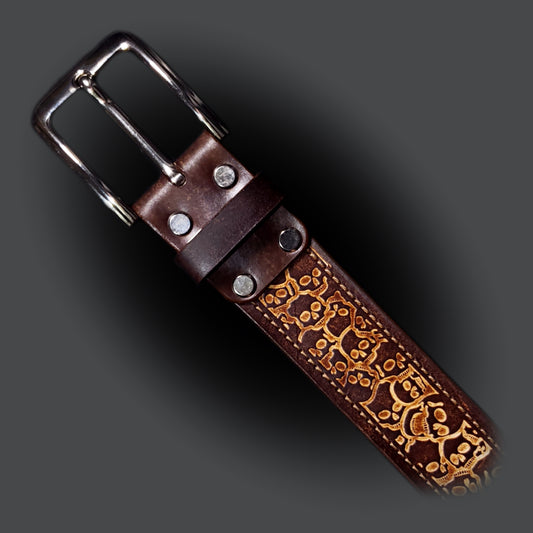 Brown leather belt with a silver buckle, decorated with a skull pattern.
