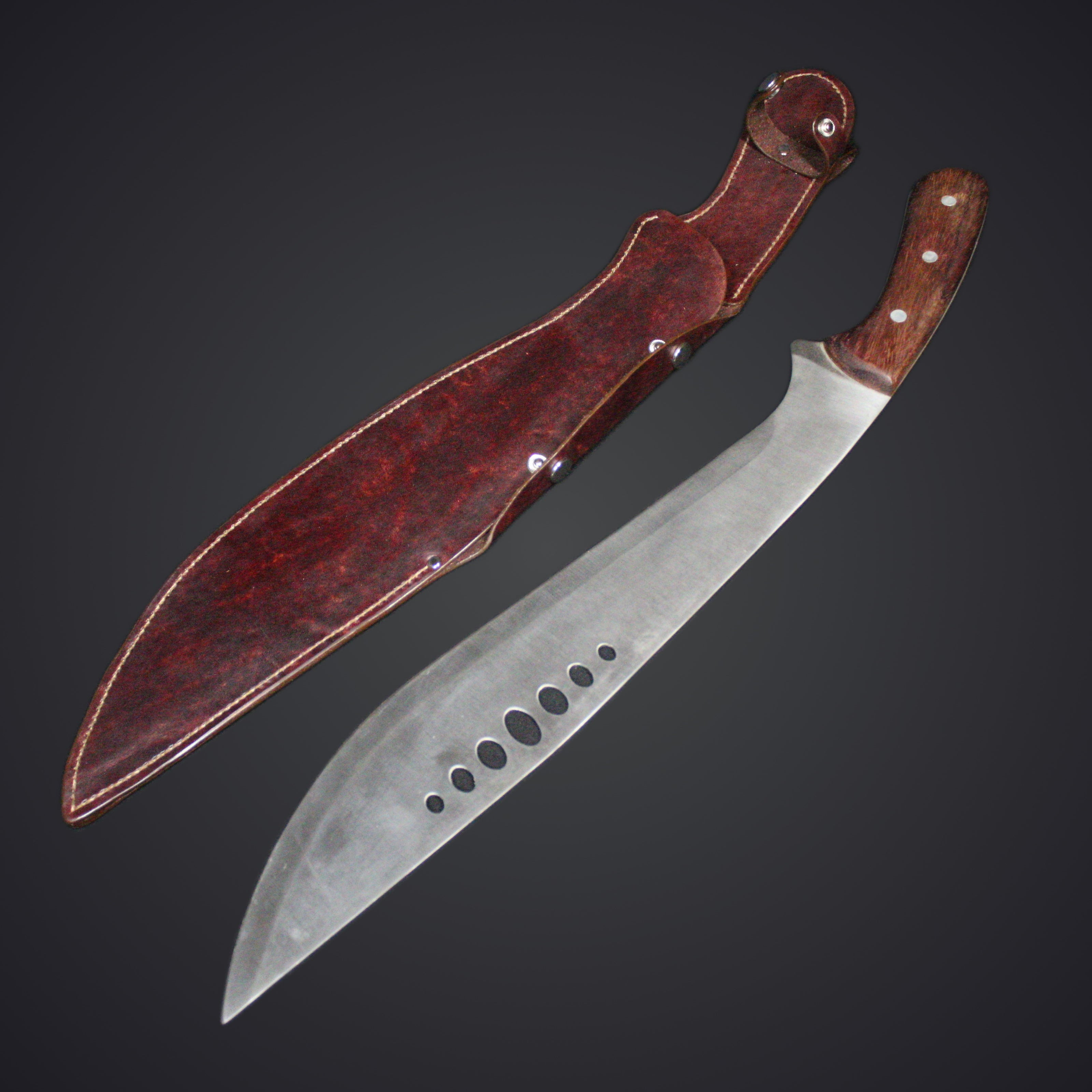 A kukri sword next to a brown leather sheath on a dark background