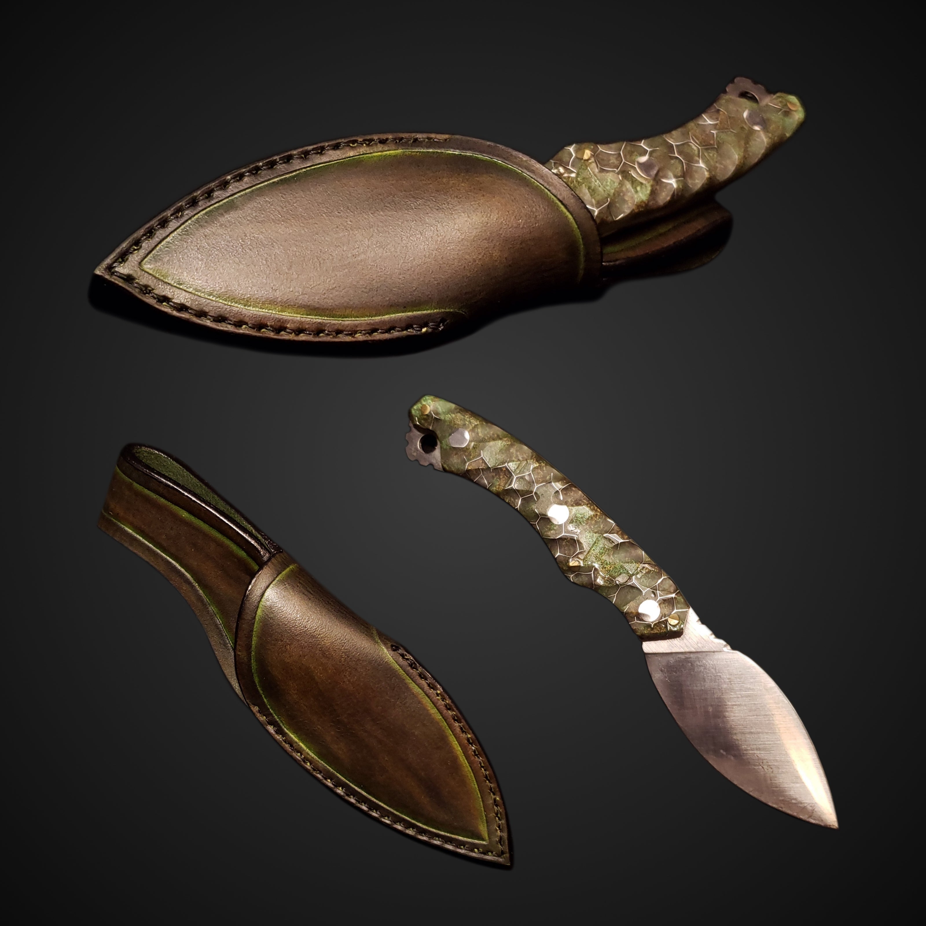 A leaf shaped knife with a green and brown handle with a color matched decorative leather sheath