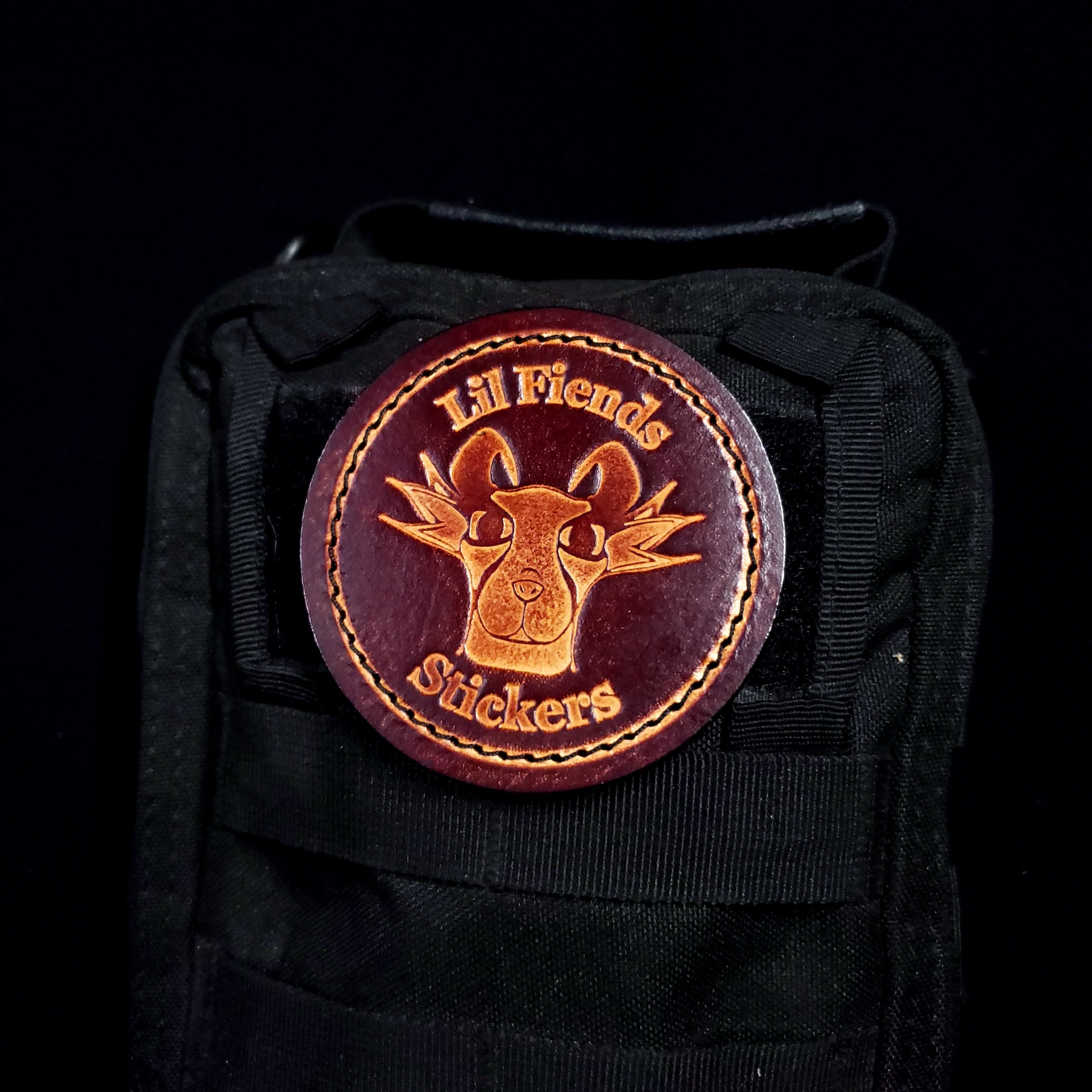 Black bag with a round leather patch featuring 'Lil Fiends Stickers' on a black background