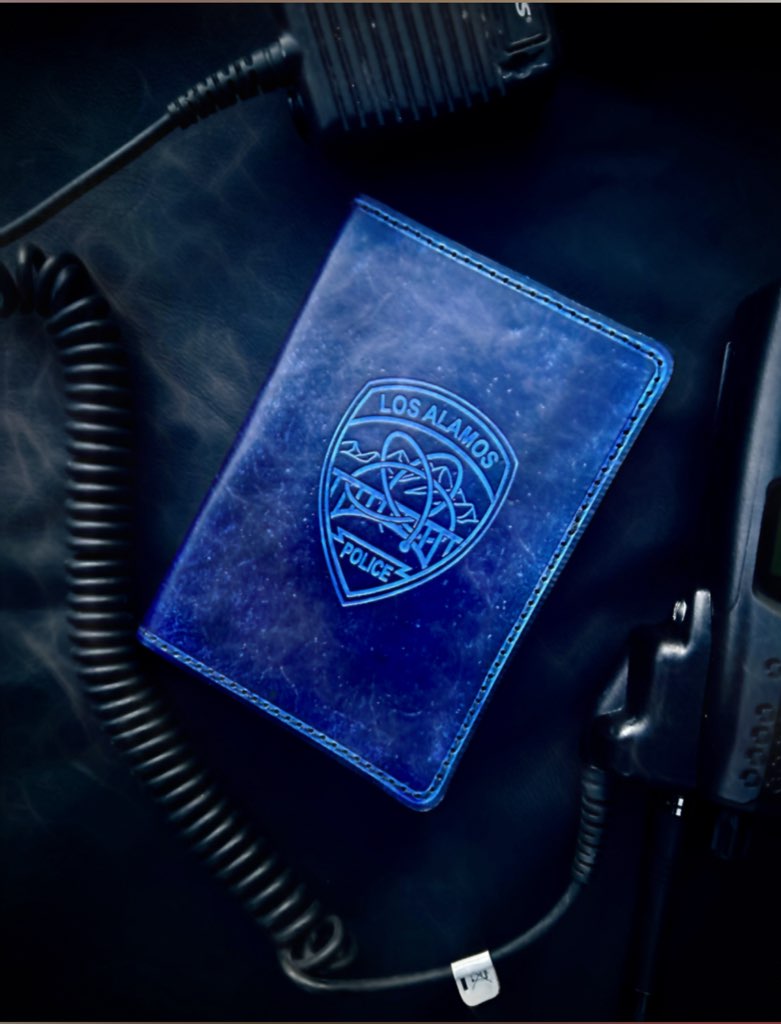 Blue leather notebook with 'Los Alamos Police' emblem on a dark background