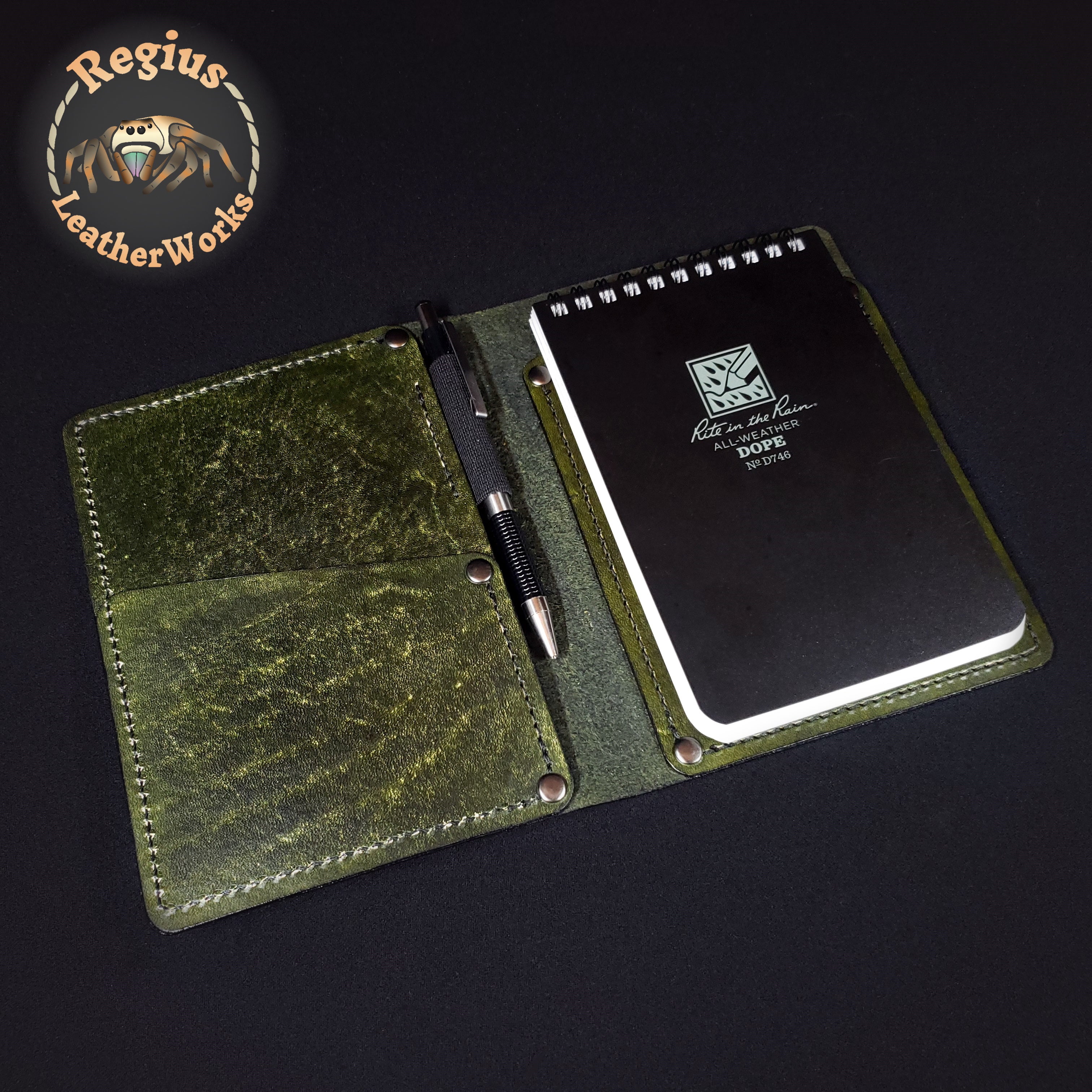 Green leather notepad cover with a pen slot on a dark background
