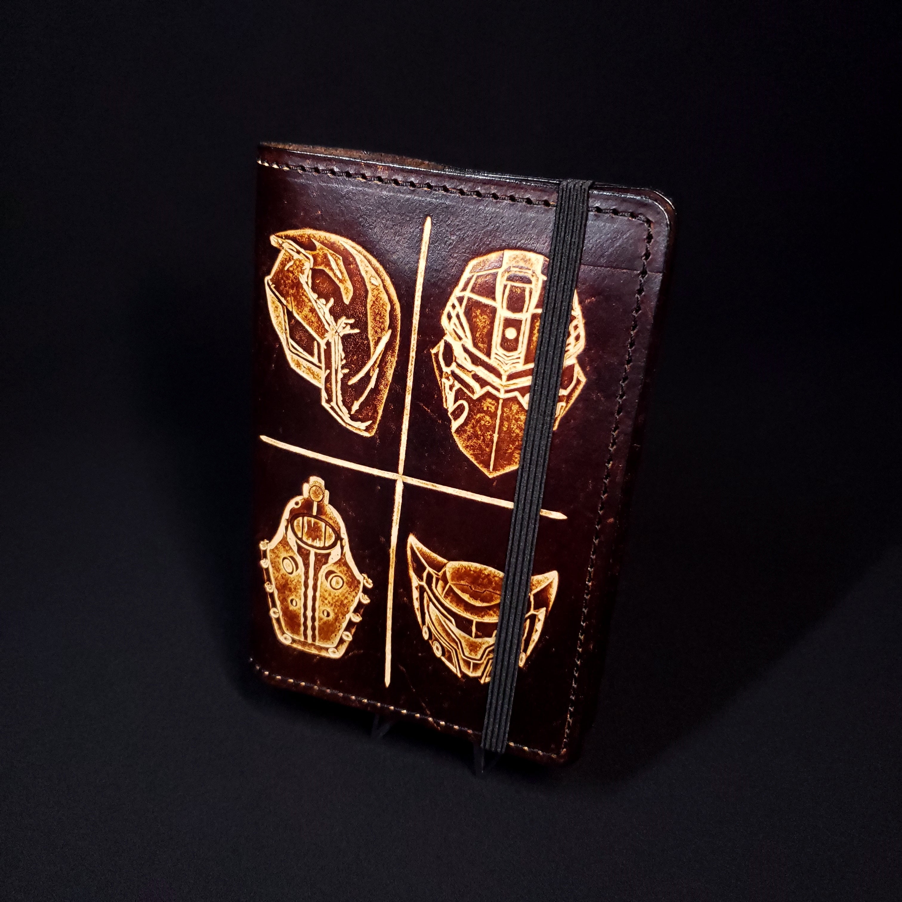 Brown leather notebook cover embossed with characters from Borderlands, Deadspace, and Bioshock.