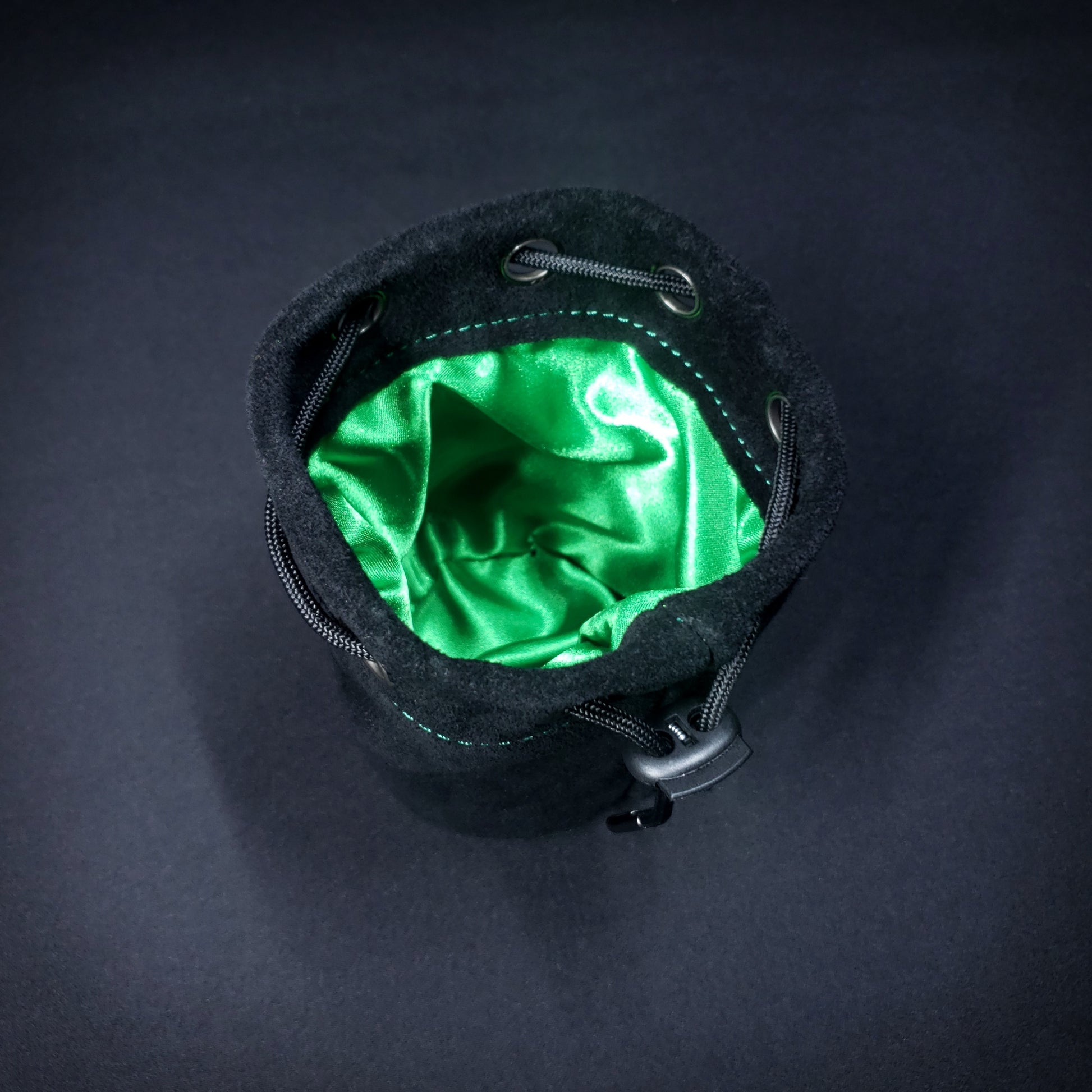 Black suede leather pouch with a black drawstring, looking down into its green satin interior.
