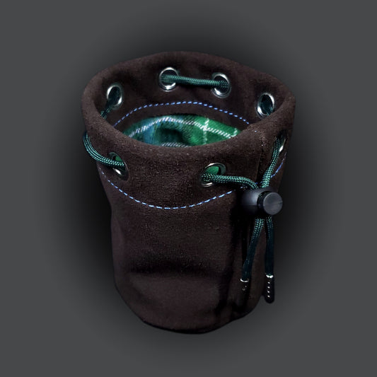 Brown suede leather pouch with a blue and green plaid cloth interior and green drawstring.
