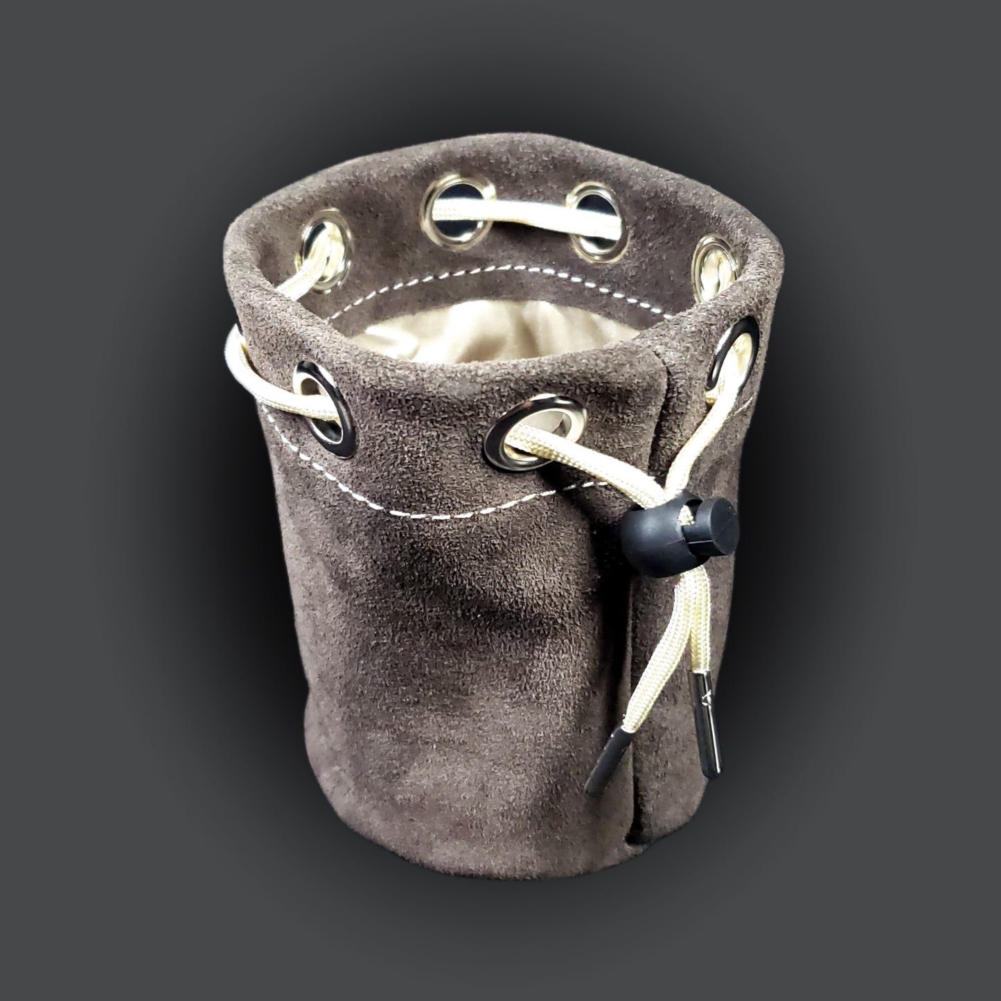 Grey suede leather pouch with a champagne colored satin interior and matching drawstring.