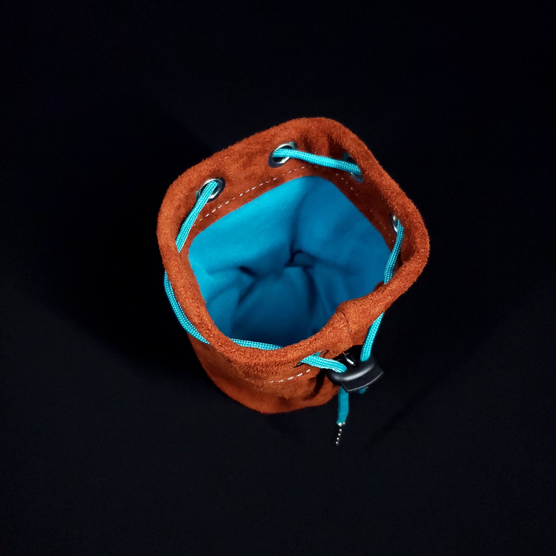Light brown suede leather pouch with a light blue drawstring, looking down into its light blue cloth interior.