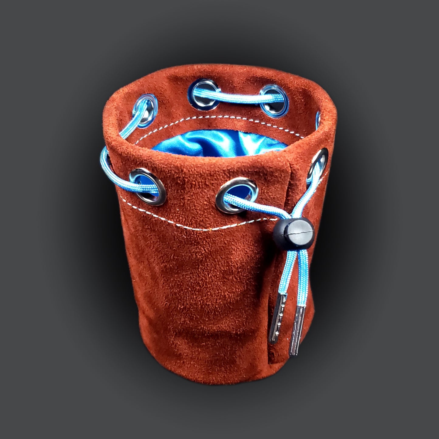 Rust colored suede leather pouch with a light blue satin interior and light blue drawstring.