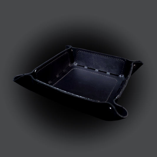 Black leather dice tray with black stitching and gun metal buttons, viewed from the front.