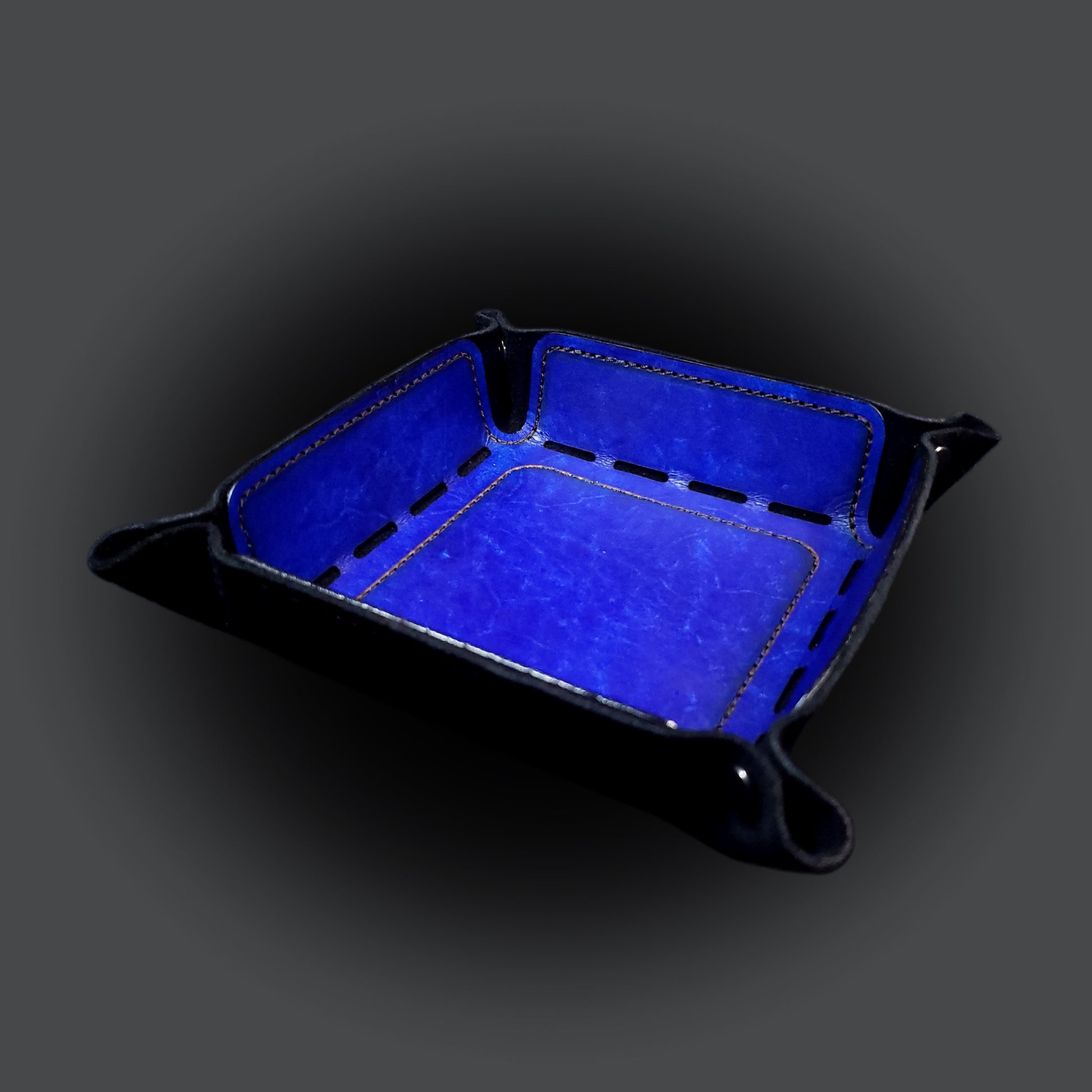 Blue leather dice tray with black stitching and gun metal buttons, viewed from the front.