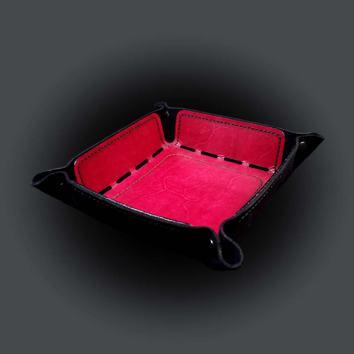 Red leather dice tray with black stitching and gun metal buttons, viewed from the front.