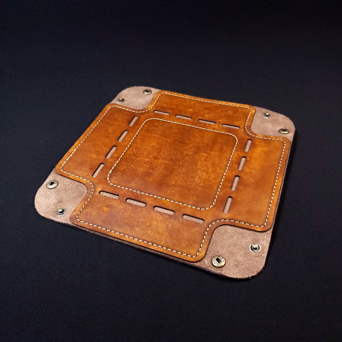 Walnut brown leather dice tray with brown stitching and bronze buttons, opened and laid flat.