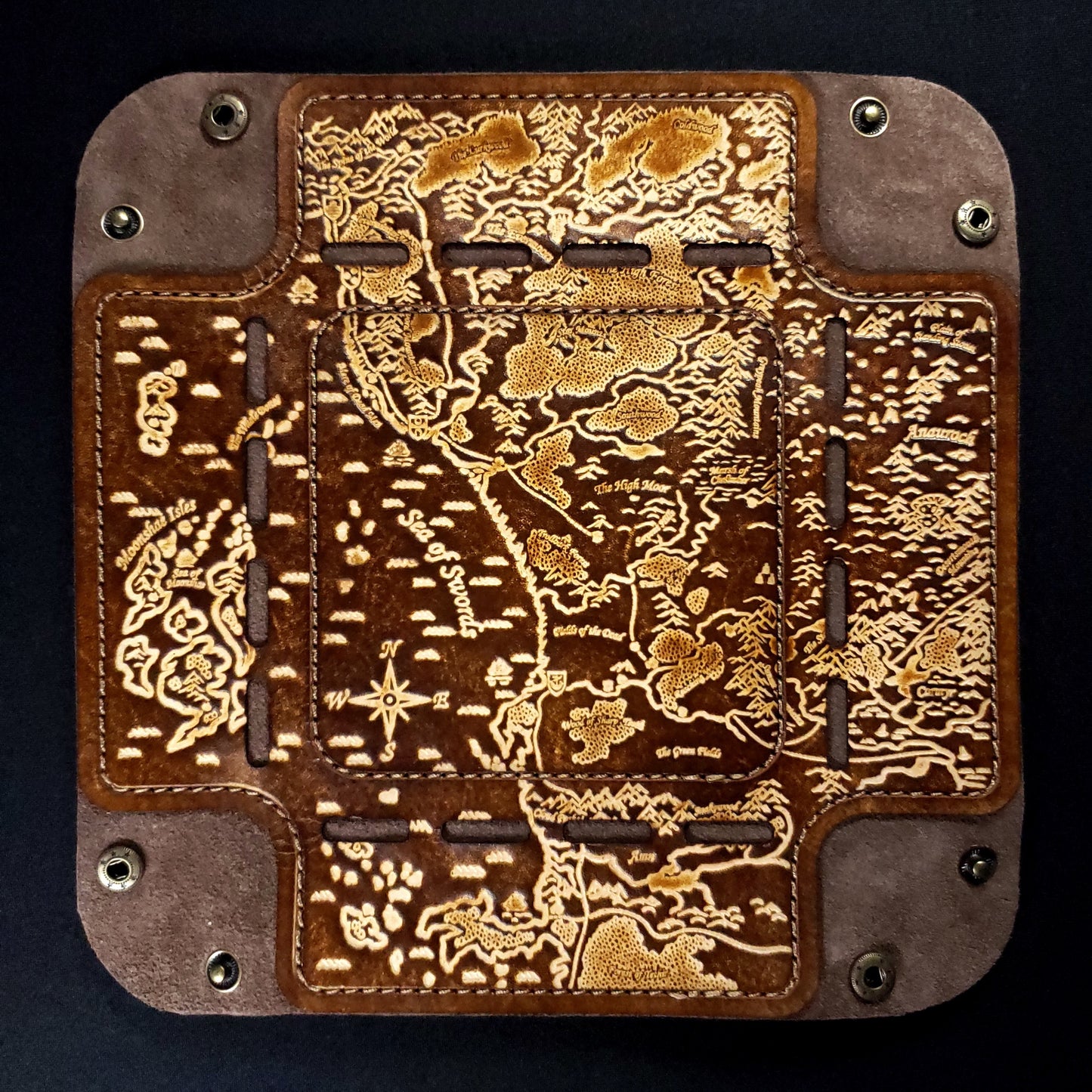 Brown leather dice tray with a fantasy map design, viewed from above to show its details