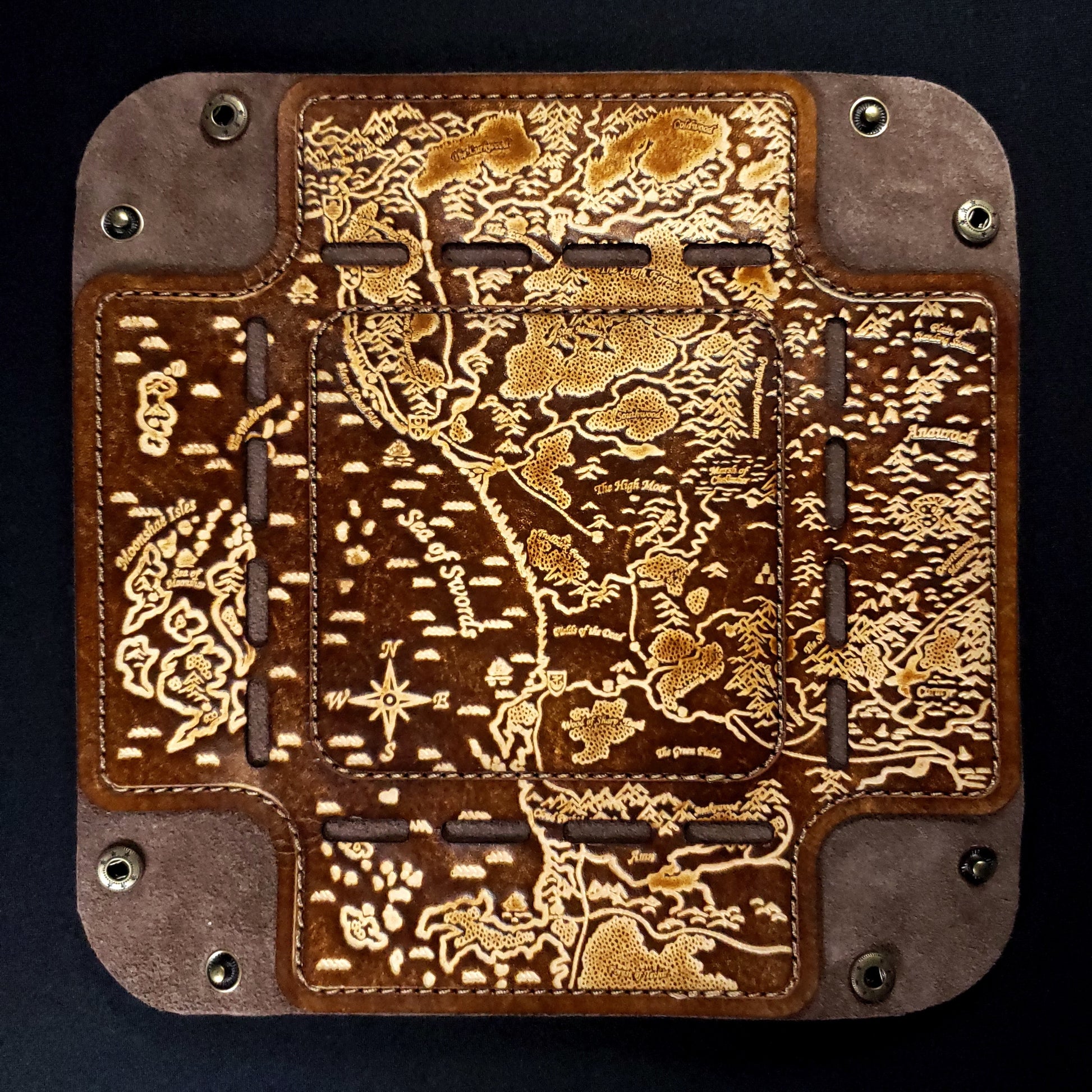 Brown leather dice tray with a fantasy map design, viewed from above to show its details