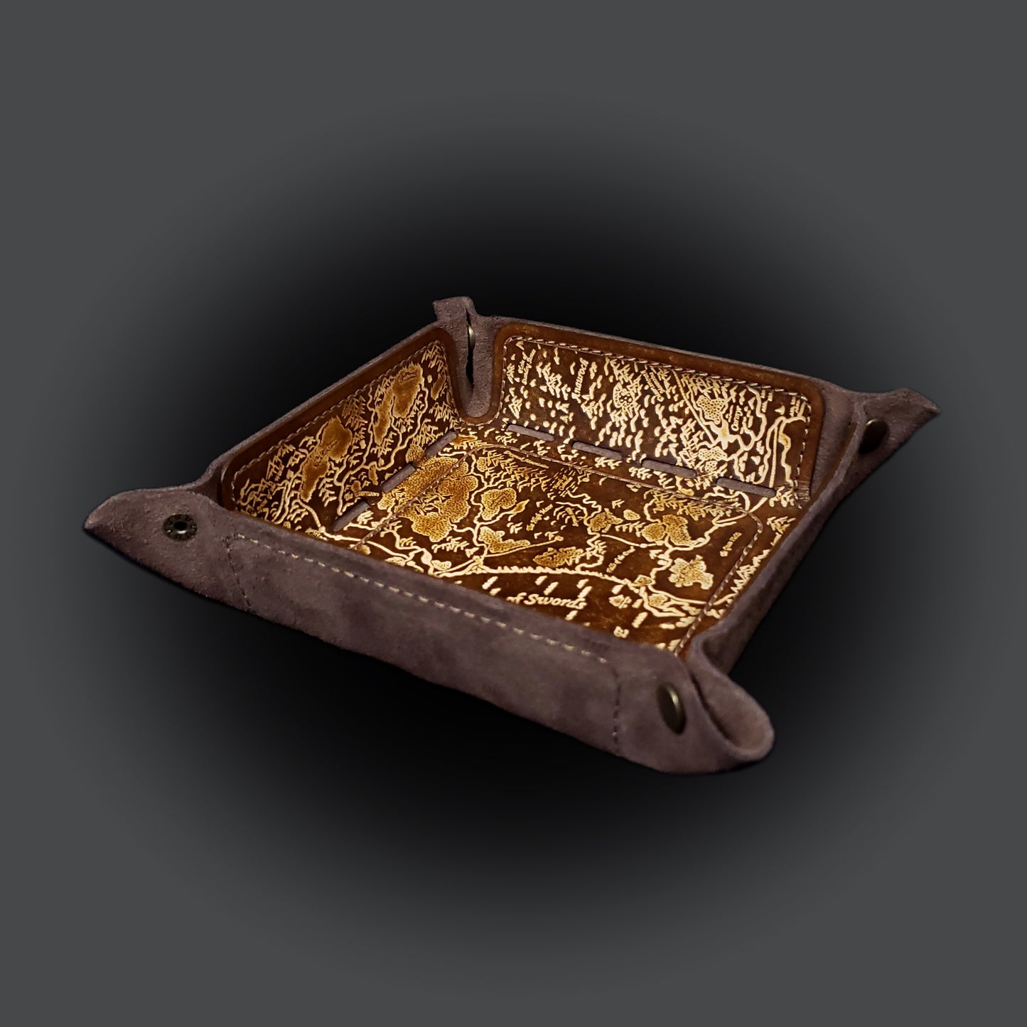 Brown leather dice tray decorated with a fantasy map  of the sword coast, viewed from the side.