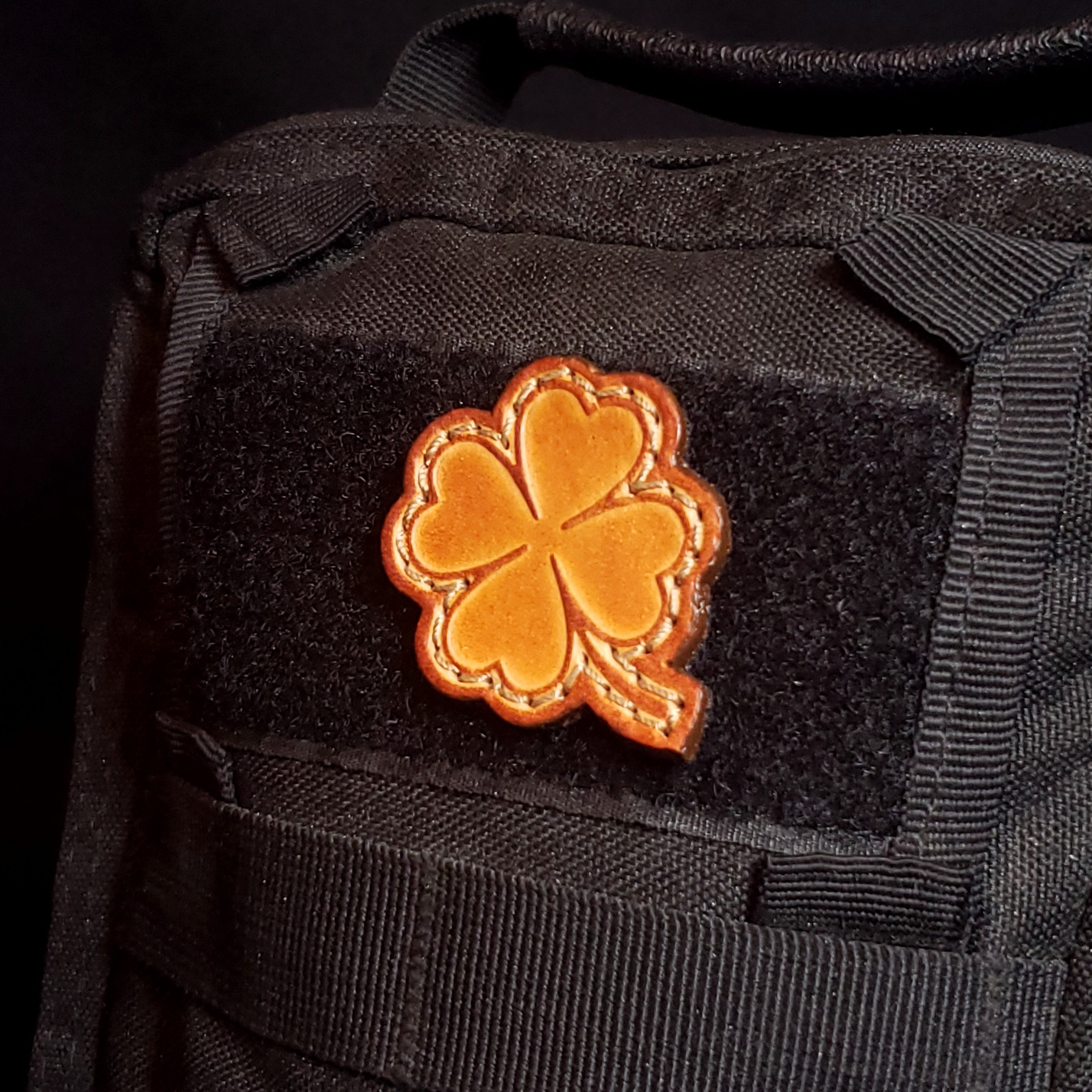 Black tactical pouch with a four leaf clover velcro patch