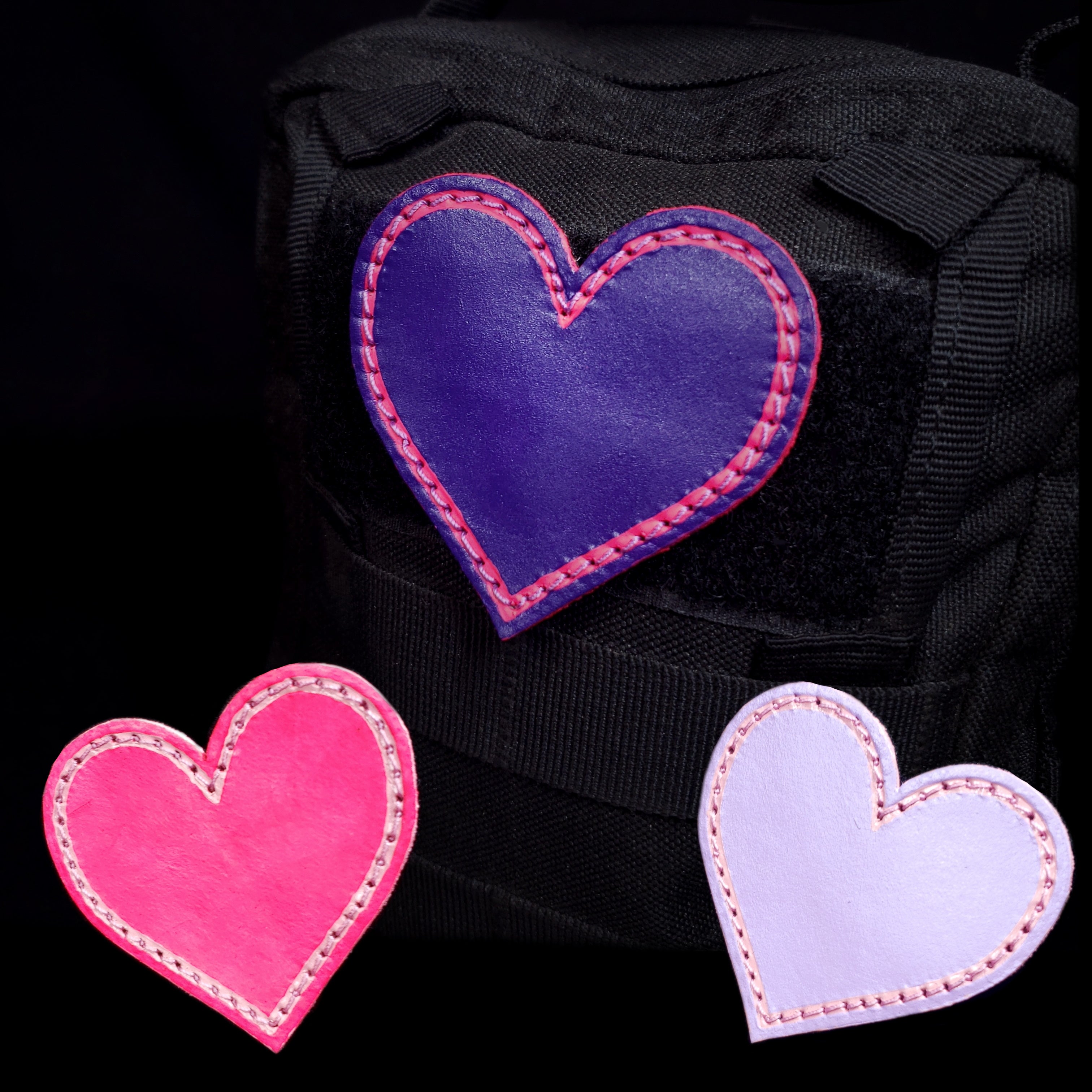 Three heart shaped velcro patches in pink and purples