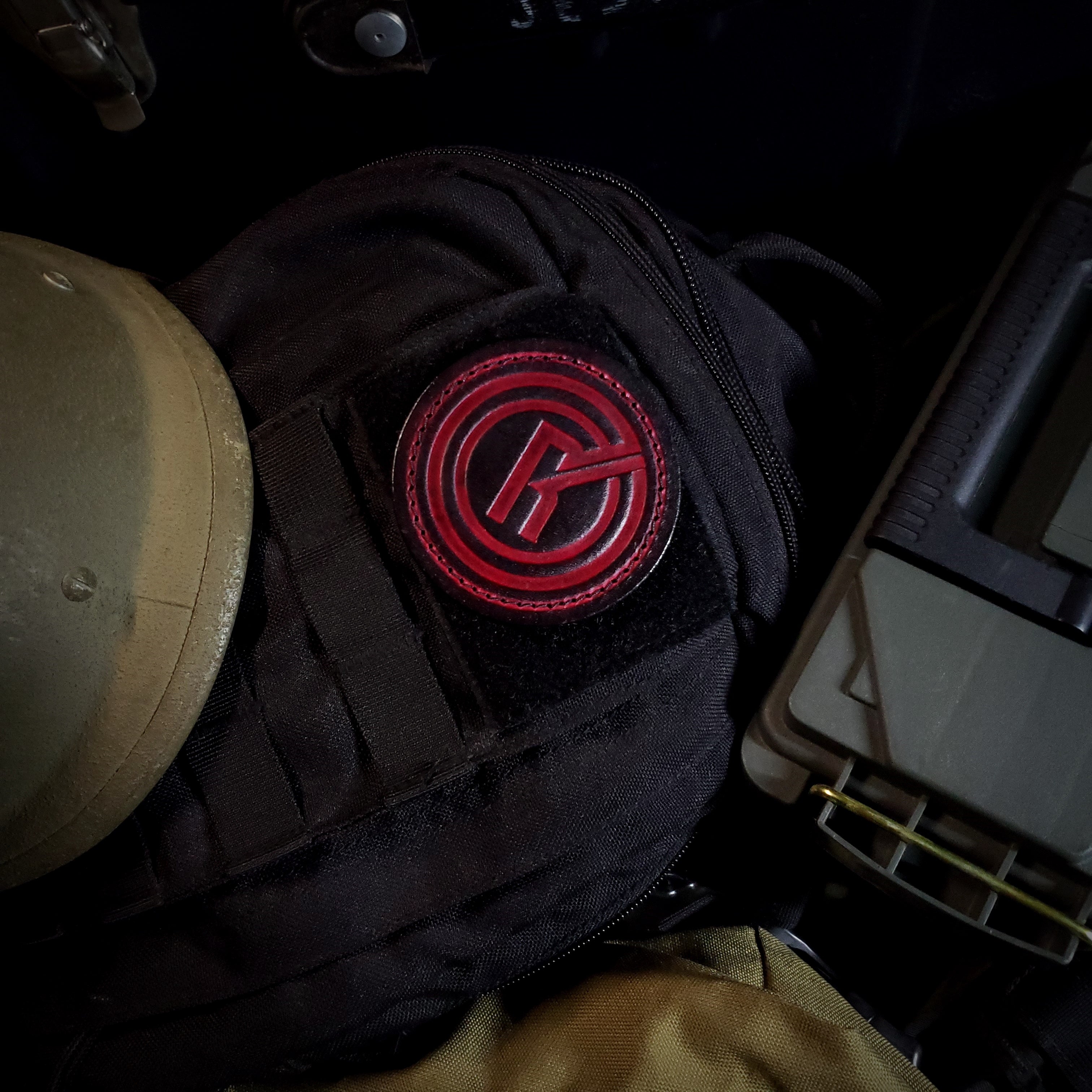 Tactical gear with a black and red velcro patch of the 'Into the Radius' video game emblem.