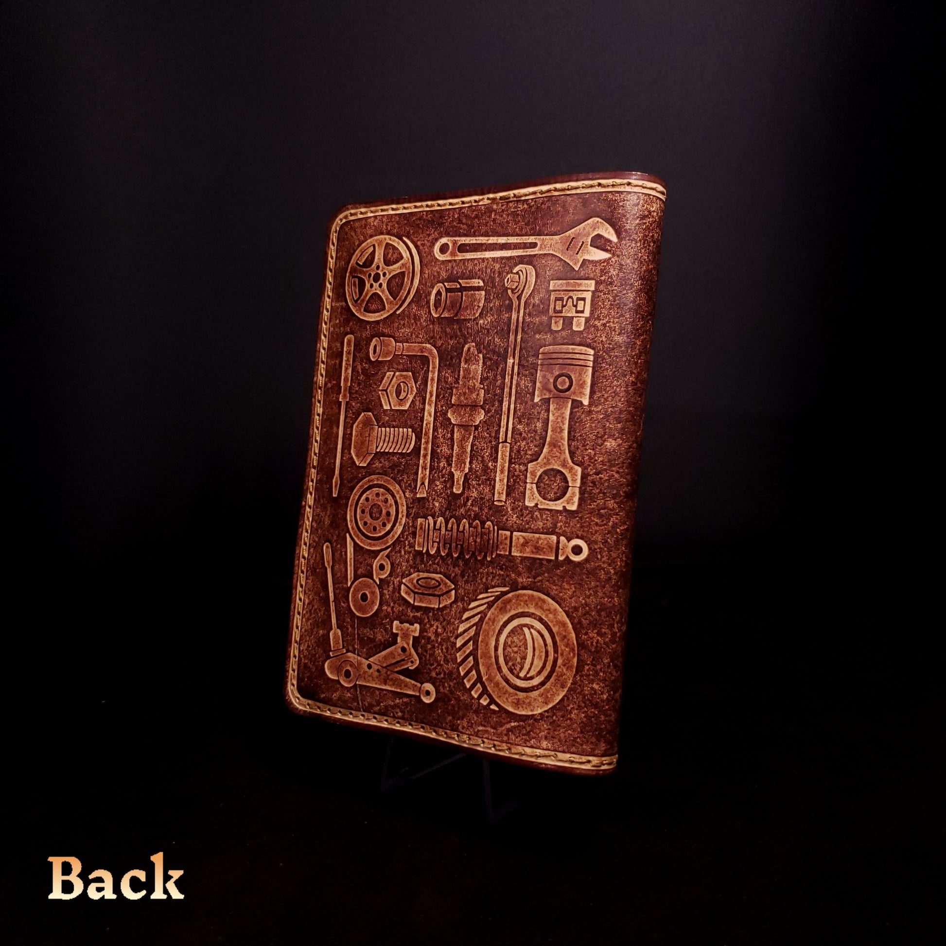 Brown leather notebook cover that's embossed with graphics of mechanic tools.