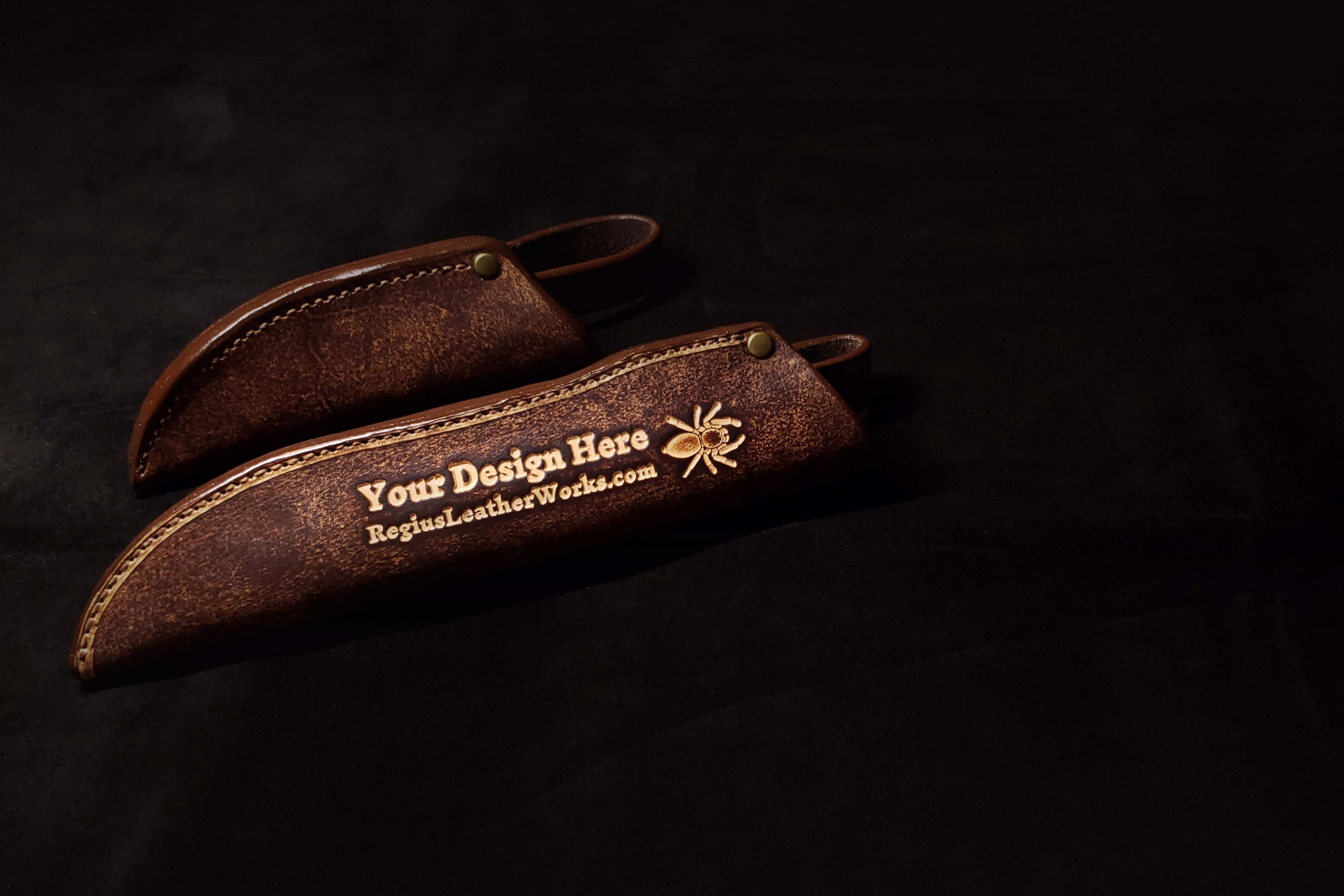 One small leather knofe sheath and one large sheath with embossed text that says "Your Design Here"