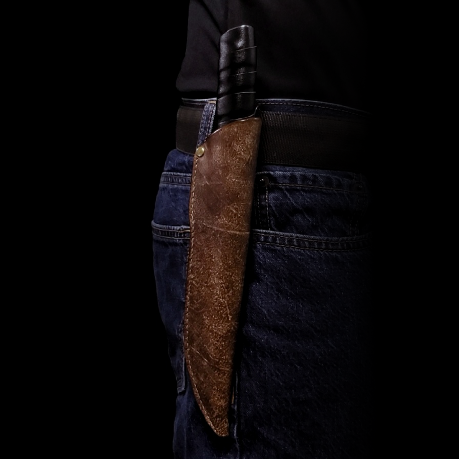 Brown leather knife sheath holding a knife, affixed to the belt on a man's waist.