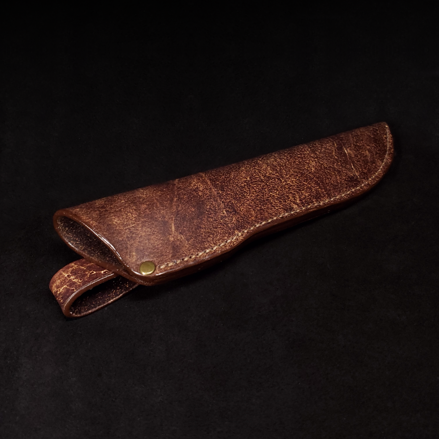 Brown leather knife sheath, viewed down its length from its opening.