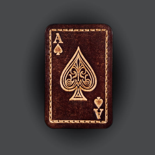 Brown rectangular velcro patch embossed with graphics and letters to resemble an ace of spades playing card.
