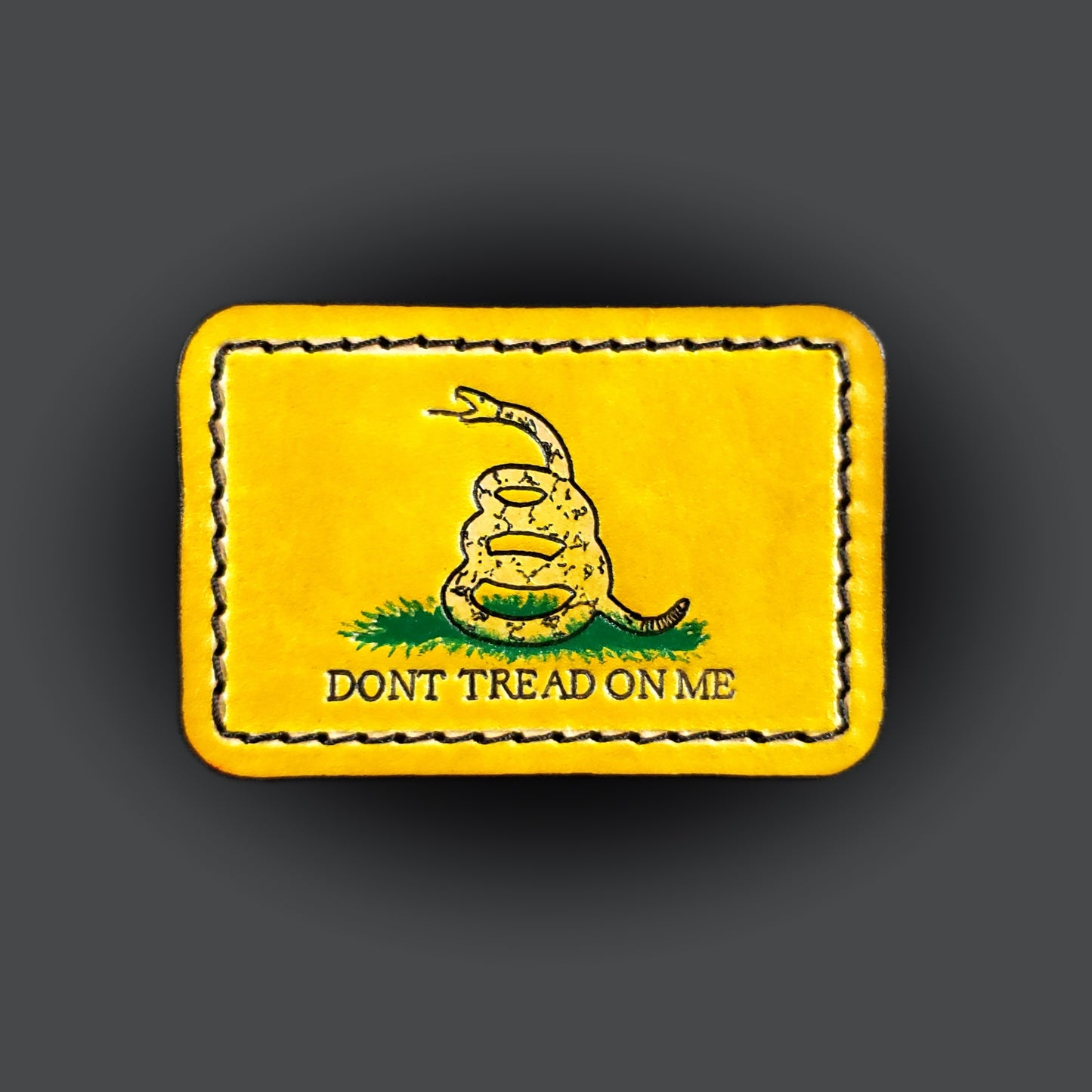 Yellow rectangular velcro patch embossed with a snake graphic and text that says "Don't tread on me".