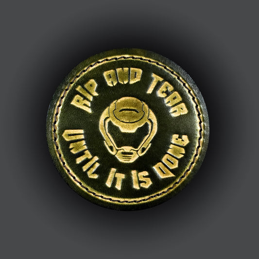 Green leather velcro patch embossed with text that says "Rip and tear until it is done" and a helmet from the Doom franchise.