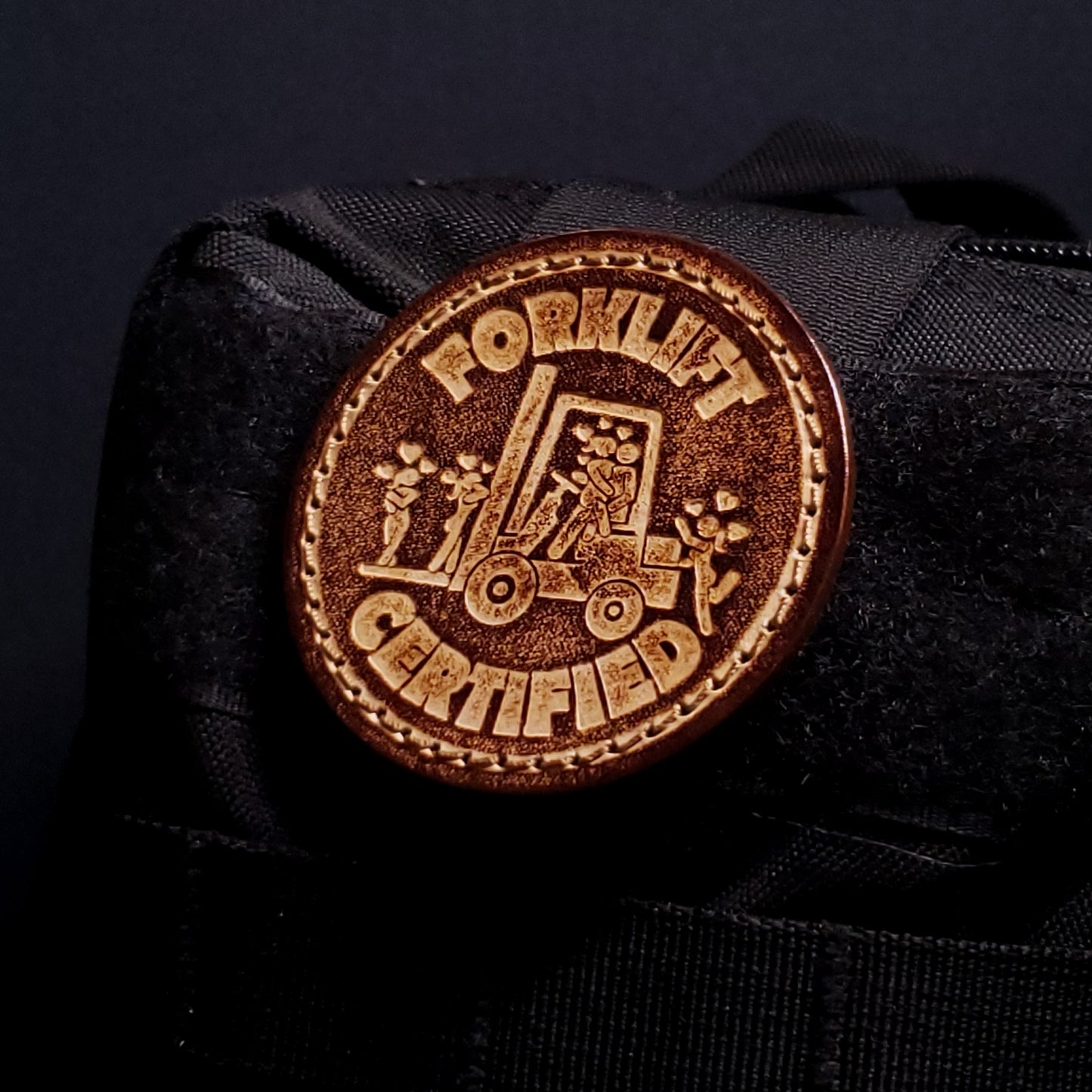 Brown leather velcro patch embossed with text and a funny graphic, affixed to a bag.