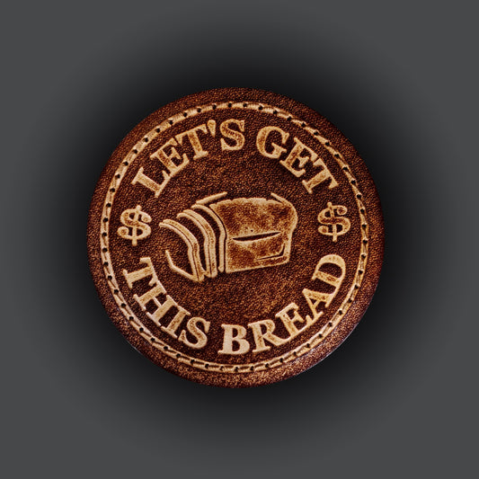 Brown leather velcro patch embossed with a graphic of bread and text that says "Let's get this bread".