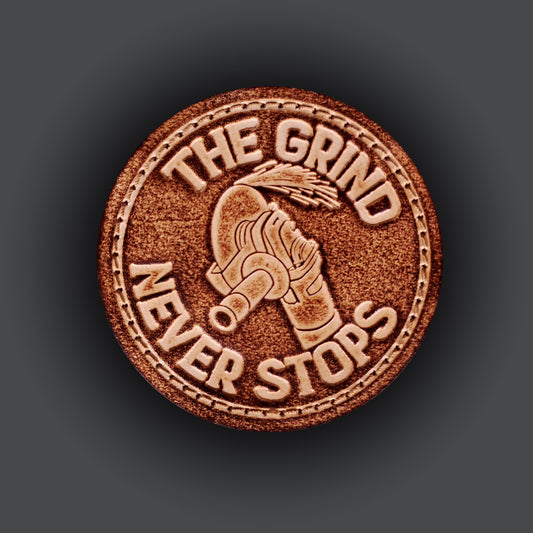 Brown leather velcro patch with text that says "The grind never stops" and an image of an angle grinder and sparks.