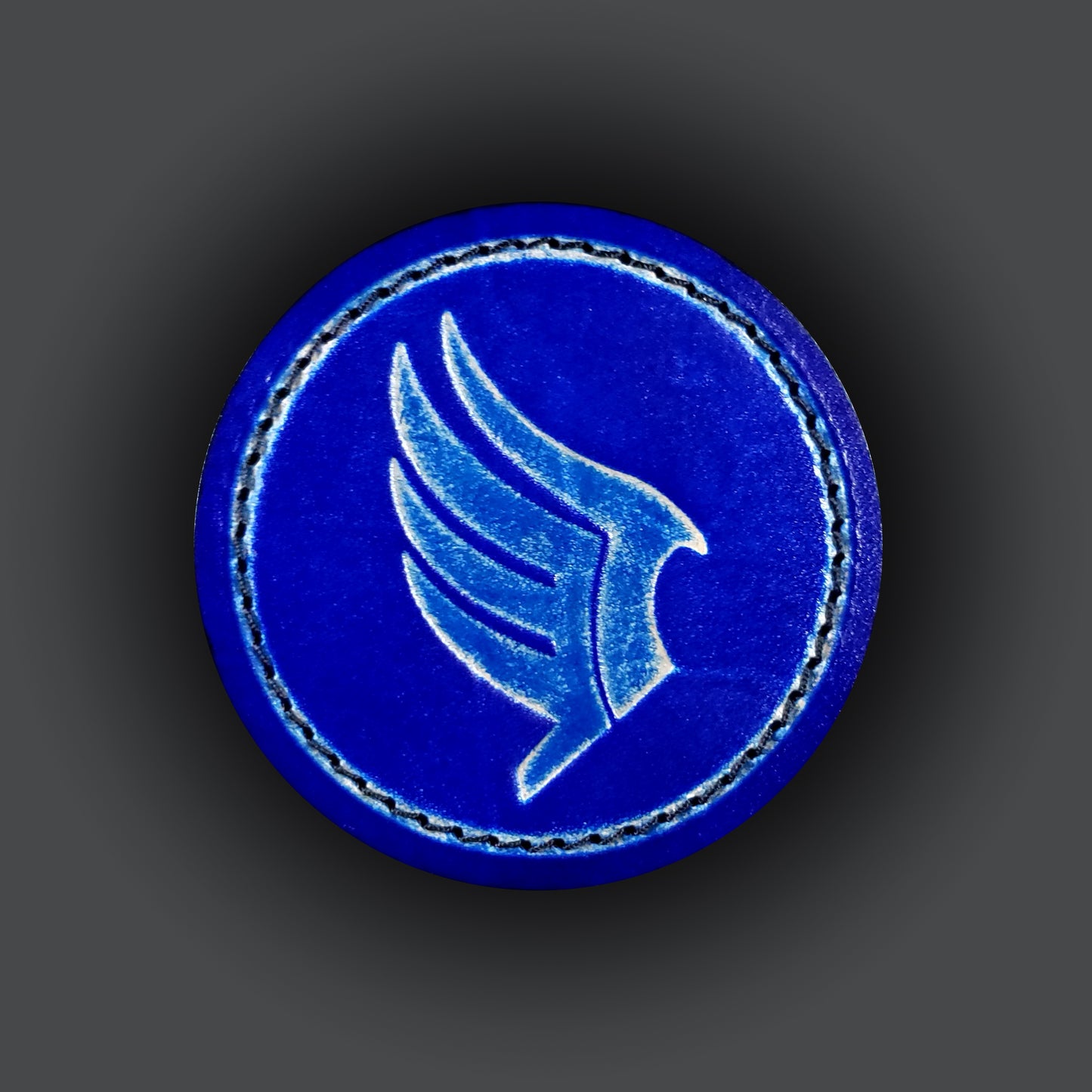 Blue leather velcro patch embossed with a wing symbol from the Mass Effect franchise.