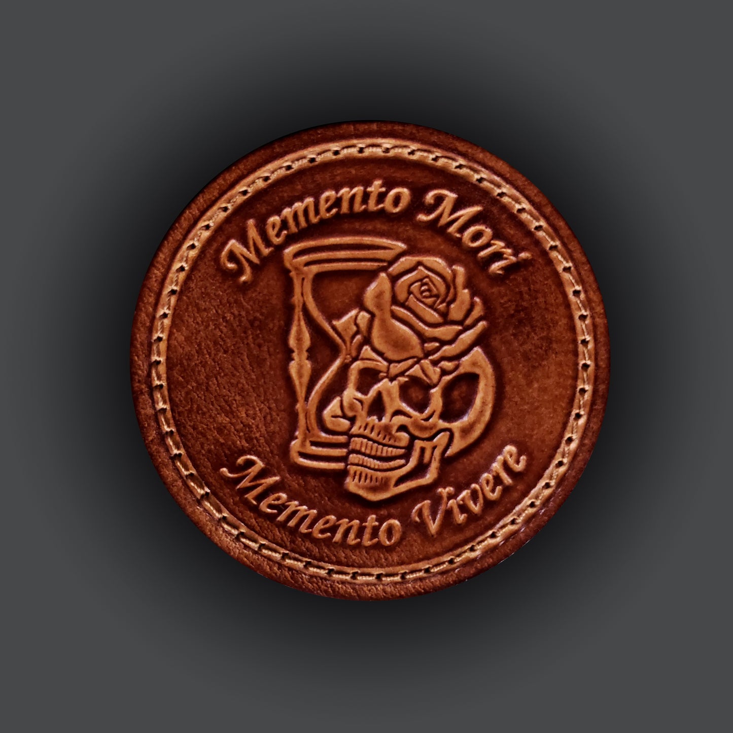 Brown leather velcro patch with text that says "Memento mori memento vivere" and an image of a skull, rose, and hourglass.