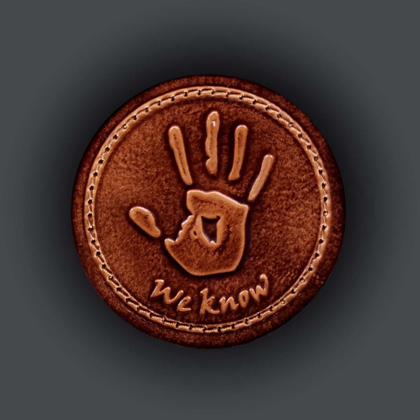 Brown leather velcro patch featuring text that says "We know", and an image of a hand print from the Elder Scrolls franchise.