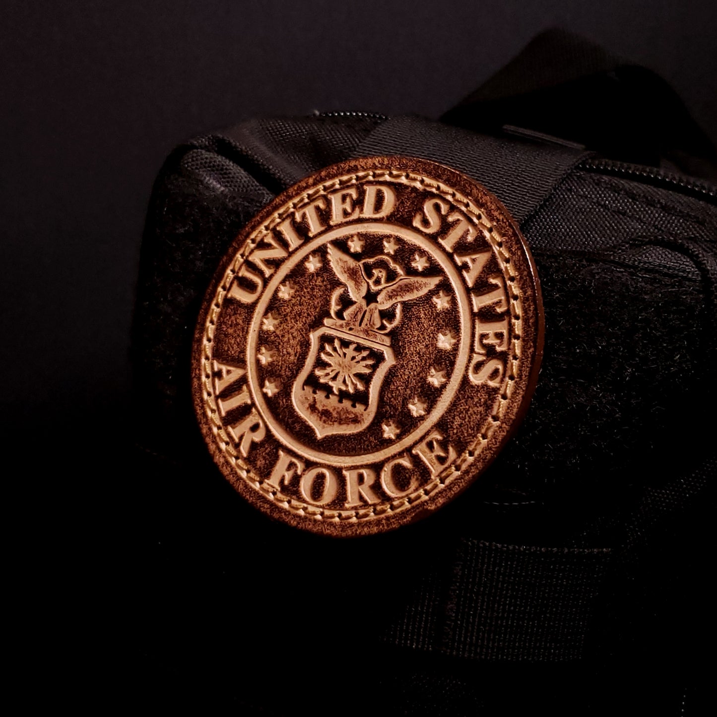 Brown leather velcro patch embossed with text and the United States Air Force emblem, affixed to a bag.