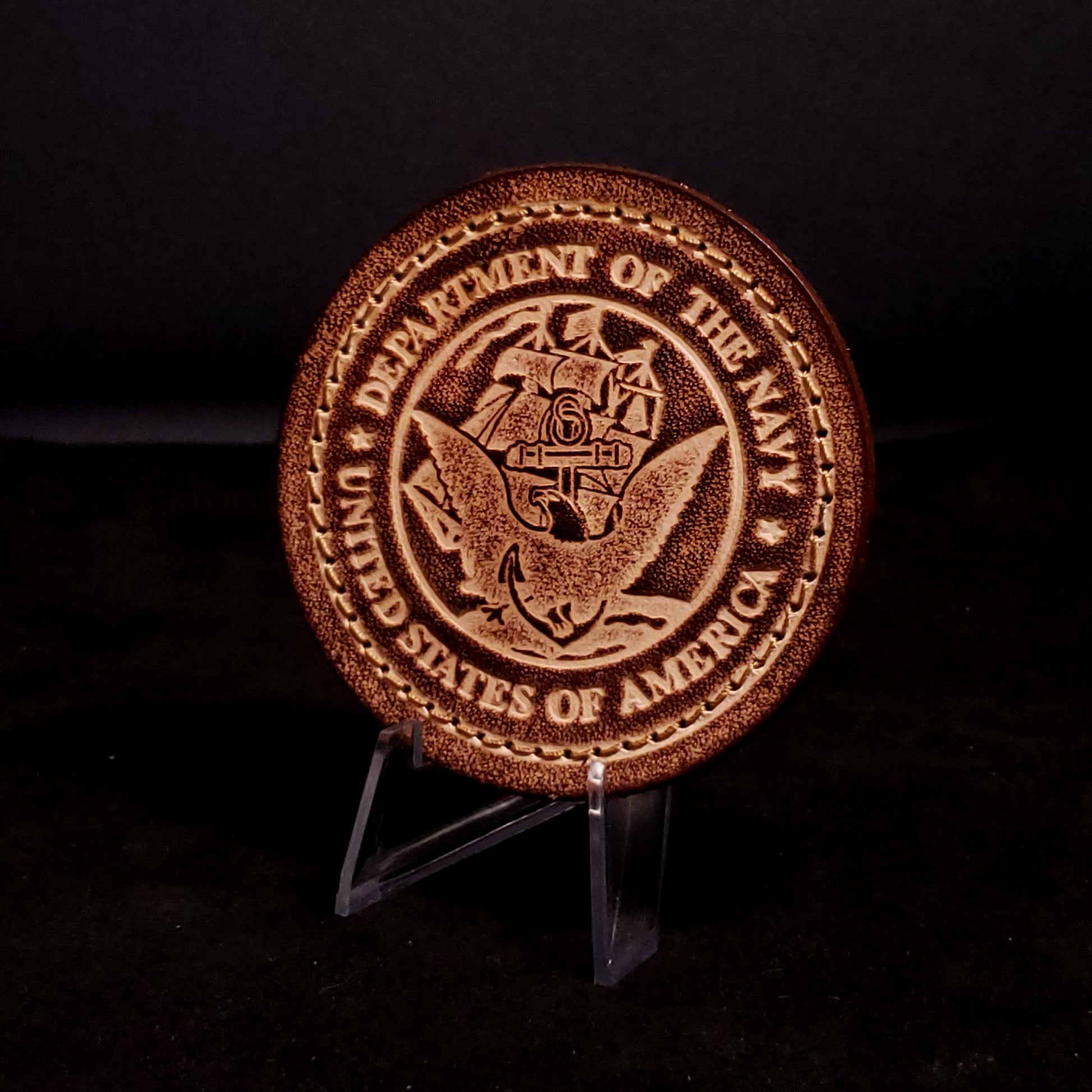 Brown leather velcro patch embossed with text and the United States Navy emblem, posed on a black background.