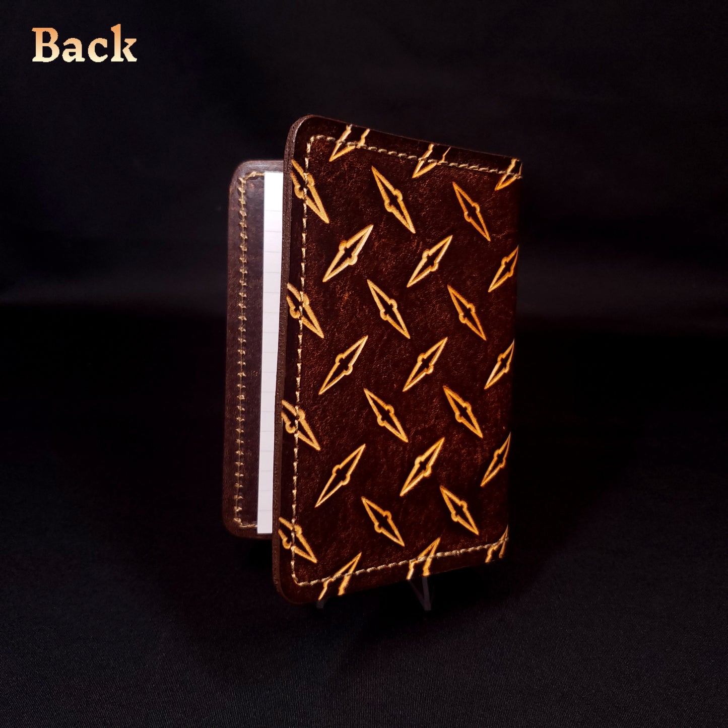 Brown leather mini-composition cover that's embossed with a diamond-plate pattern, closed and viewed from the back.