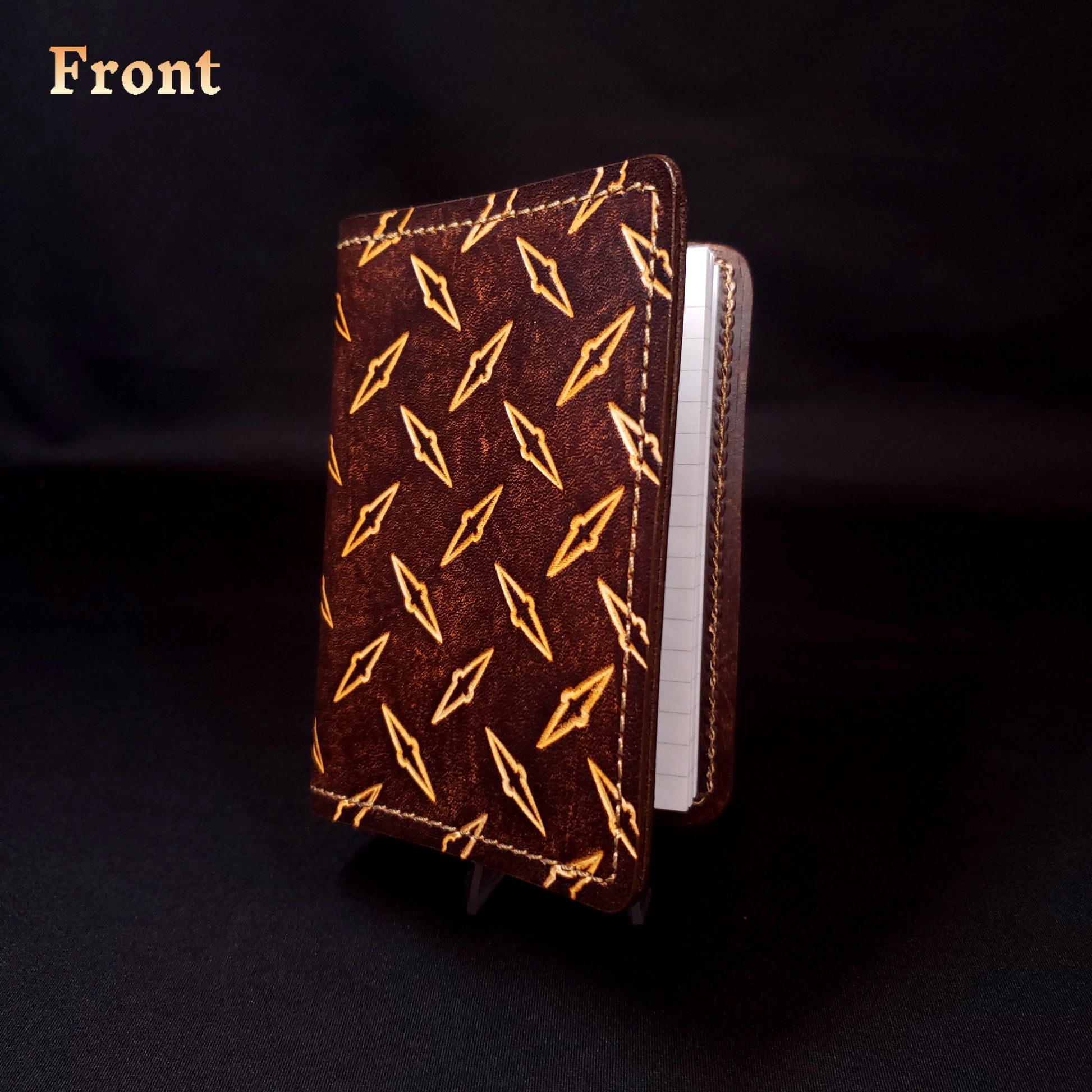 Brown leather mini-composition cover that's embossed with a diamond-plate pattern, closed and viewed from the front.