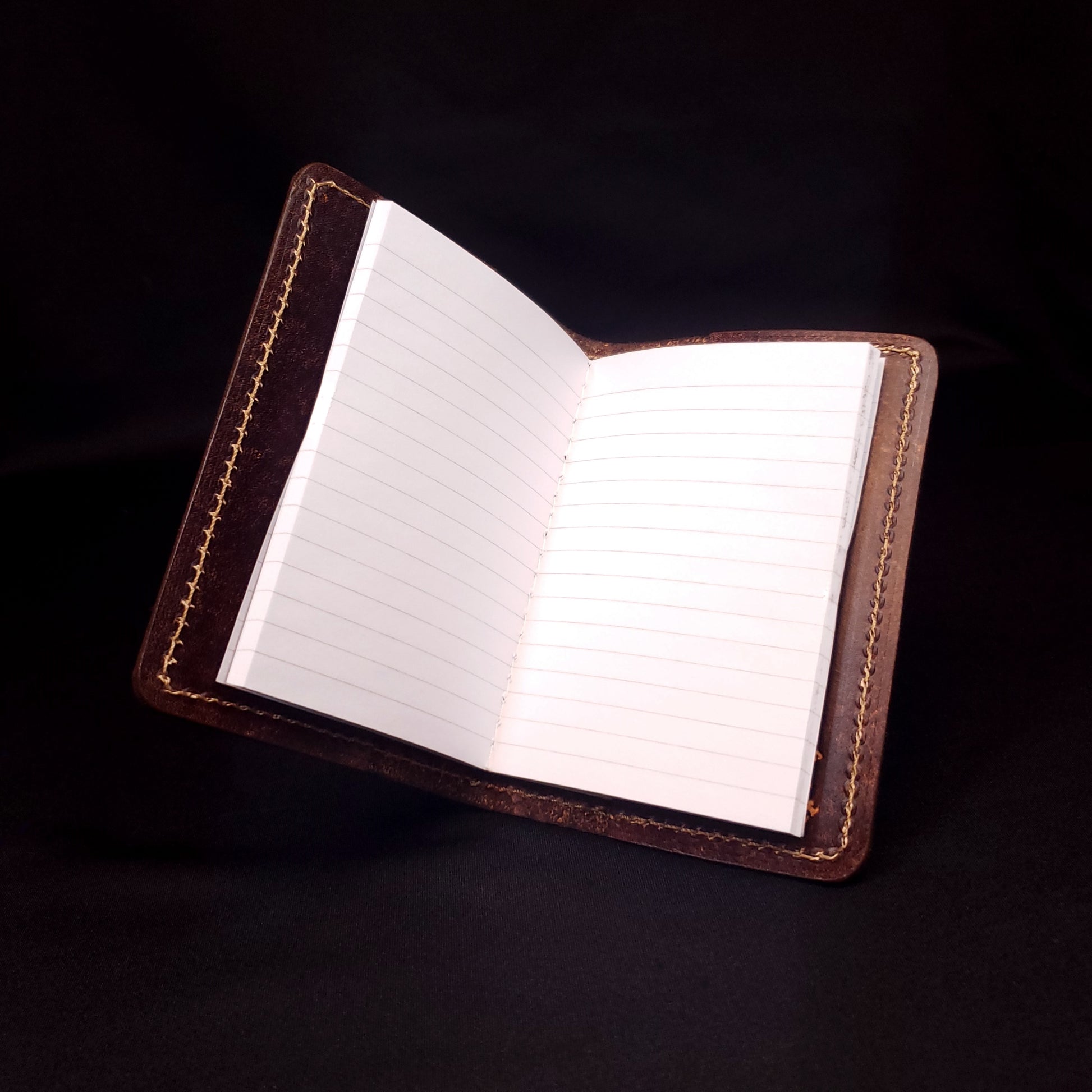 Brown leather mini-composition cover that's embossed with a diamond-plate pattern, opened with lined pages.