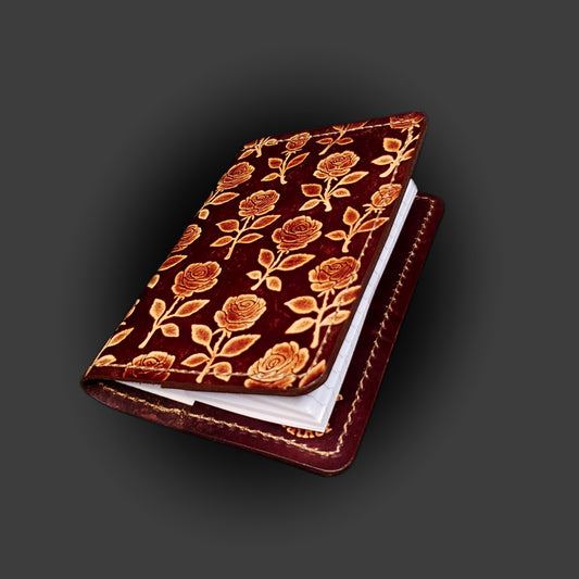 Brown leather mini-composition cover that's embossed with a floral rose pattern on a grey background.