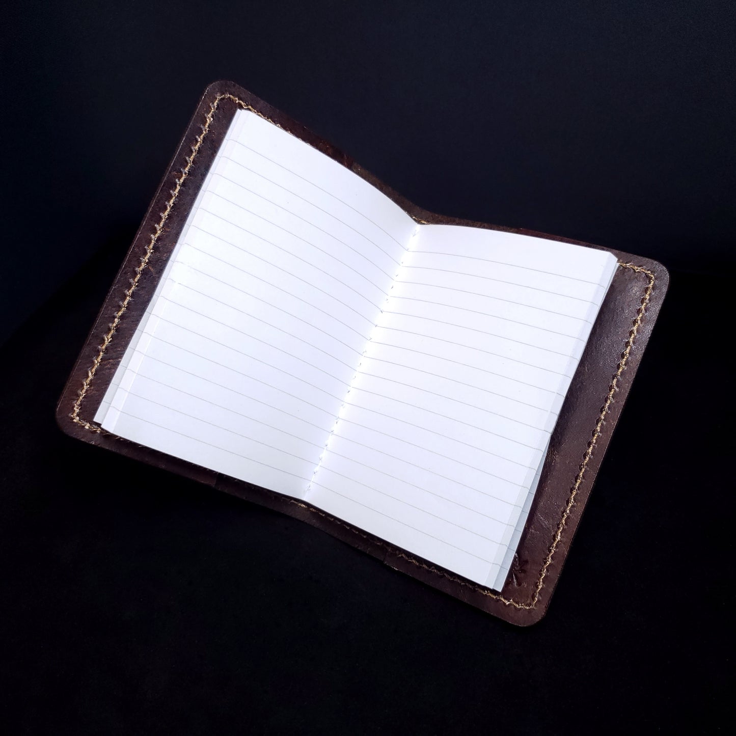 Brown leather mini-composition cover, opened with lined pages